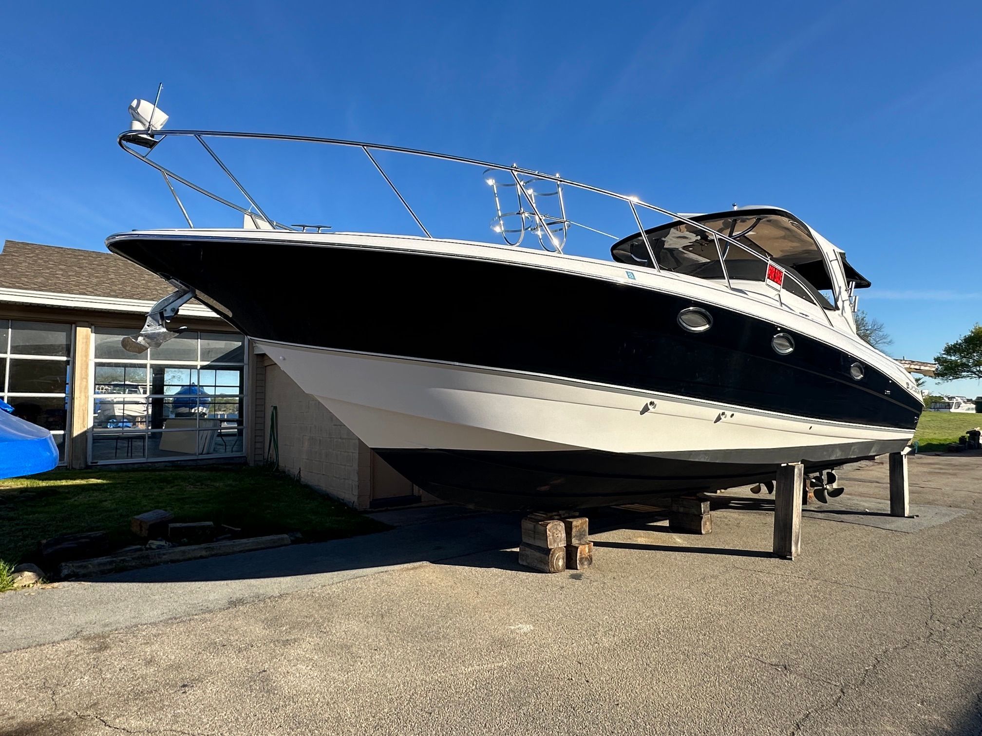 A 2007 Larson Cabrio 370 boat is on blocks on land.