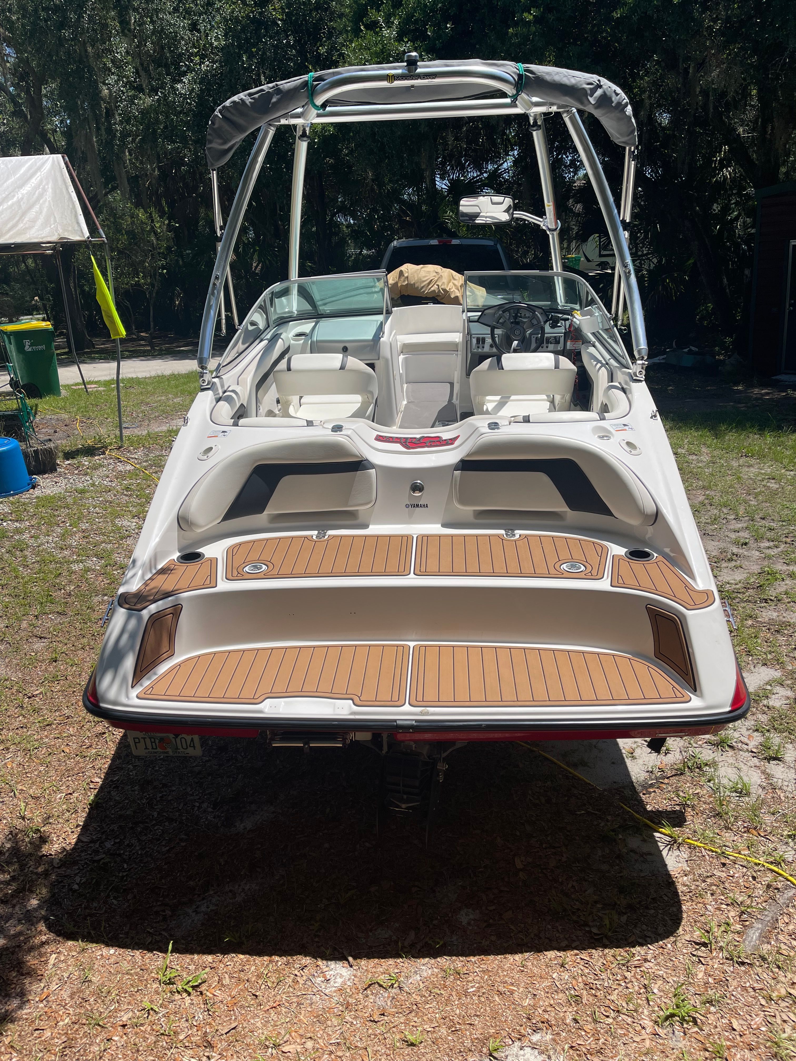 2015 Yamaha SX190 with spacious deck, white hull, and gray bimini top, parked on dry land.