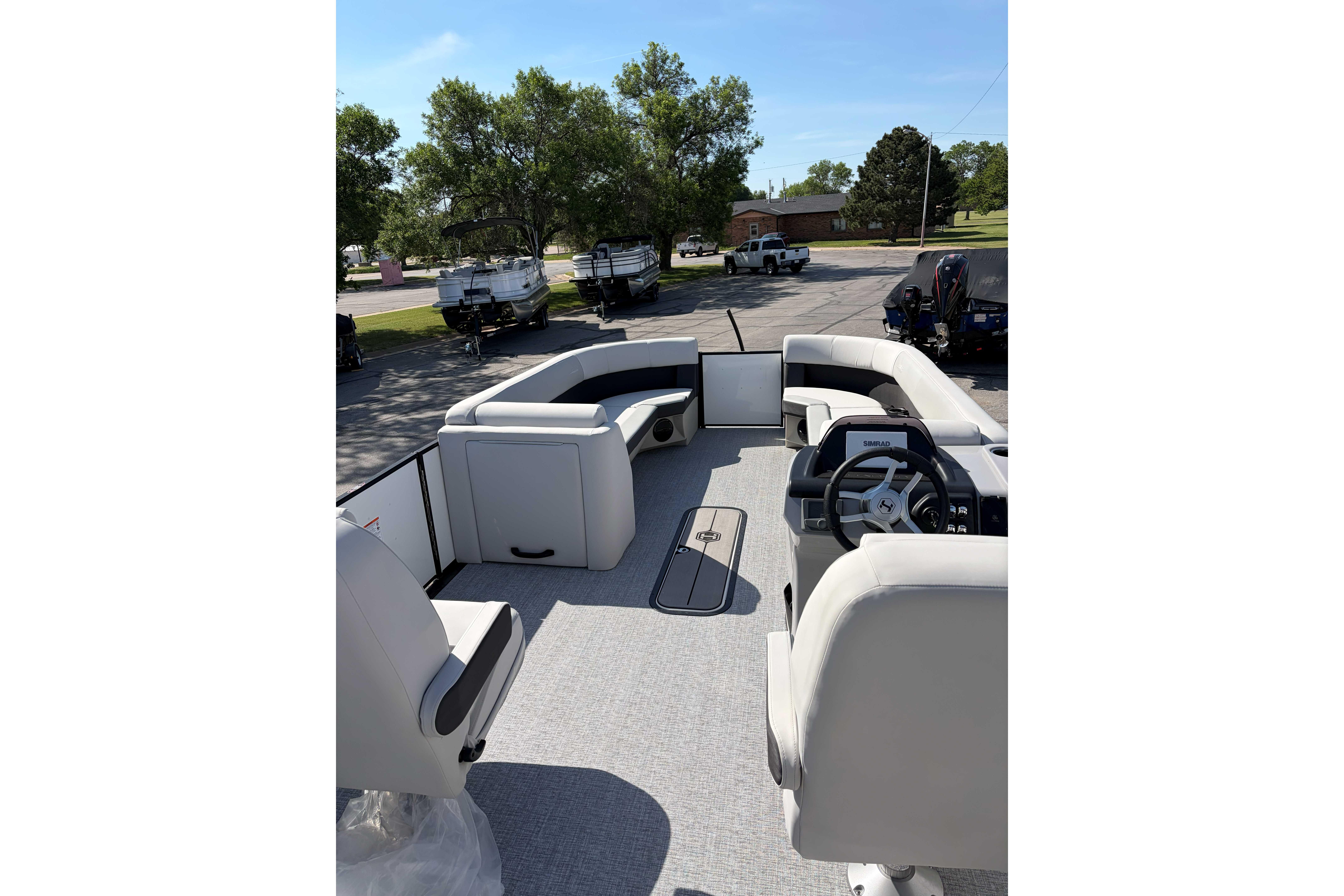 2025 Harris Cruiser 250 pontoon boat interior with plush seating and steering console.