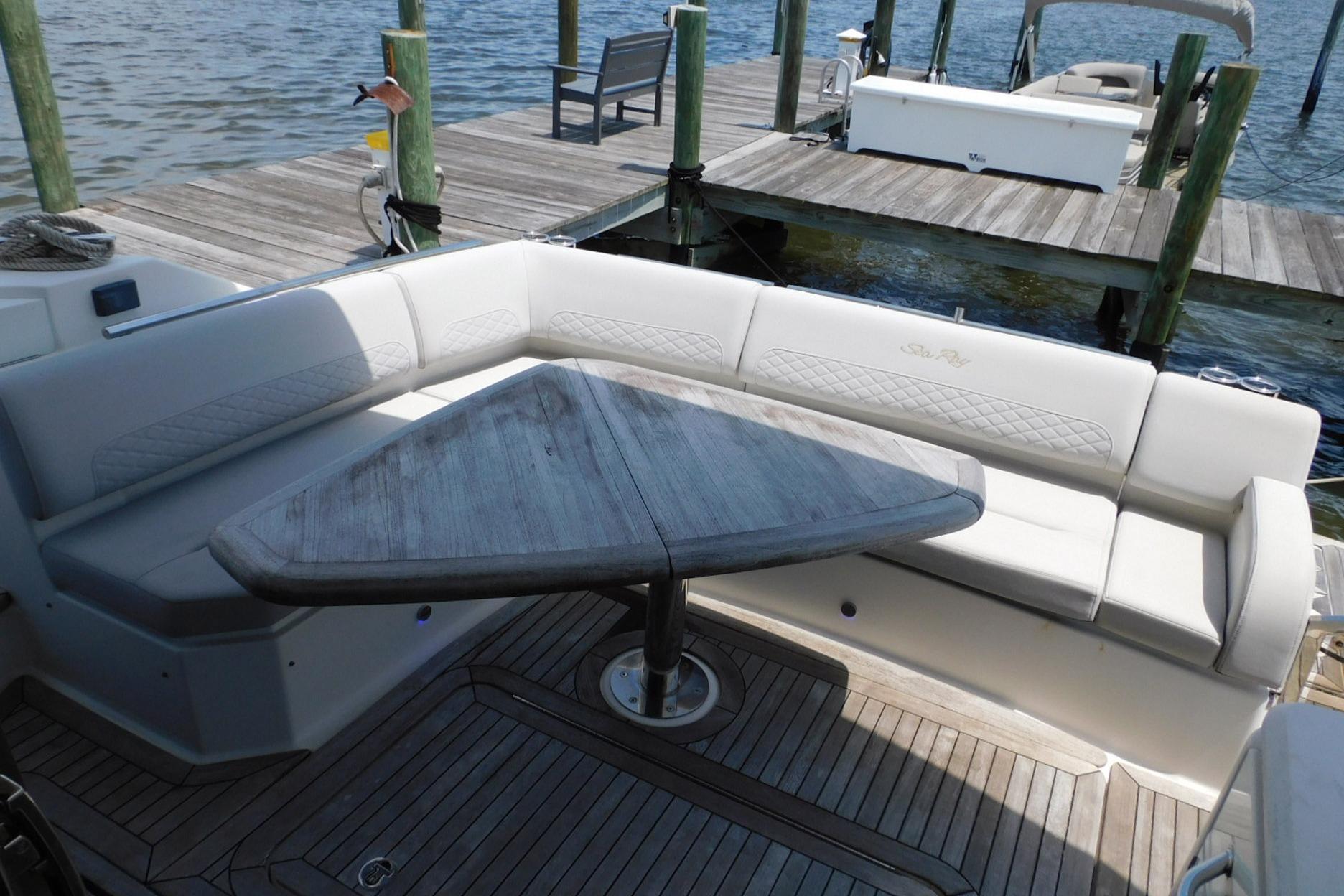 2019 Sea Ray L550 yacht with elegant seating and wooden table on deck.