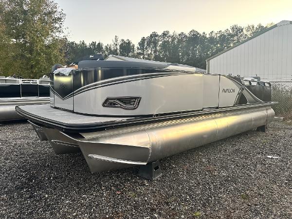 2025 Avalon LSZ Versatile Rear Lounger pontoon boat on gravel lot, side view.