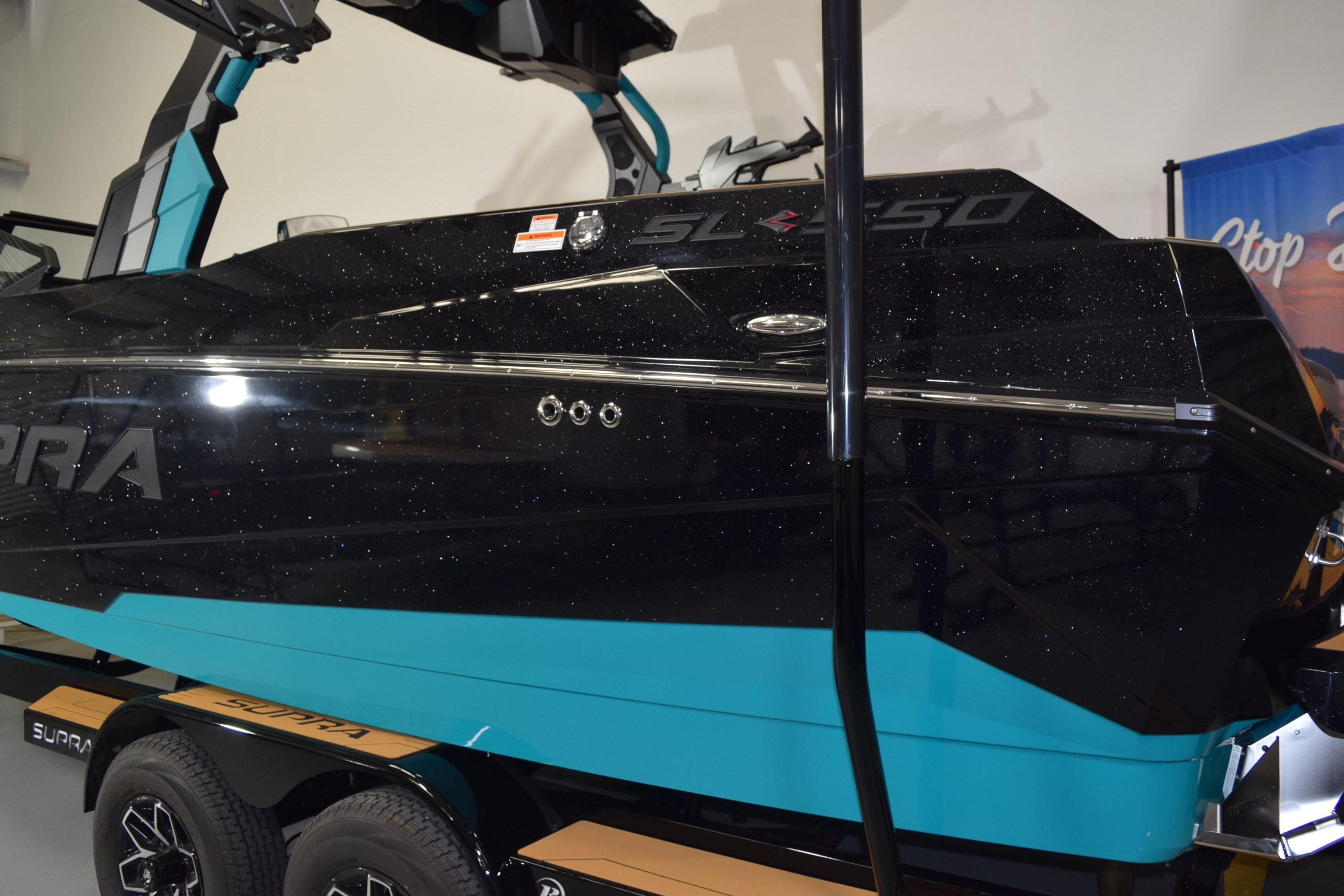 2026 Supra SL 550 boat with sleek black and turquoise design on trailer.