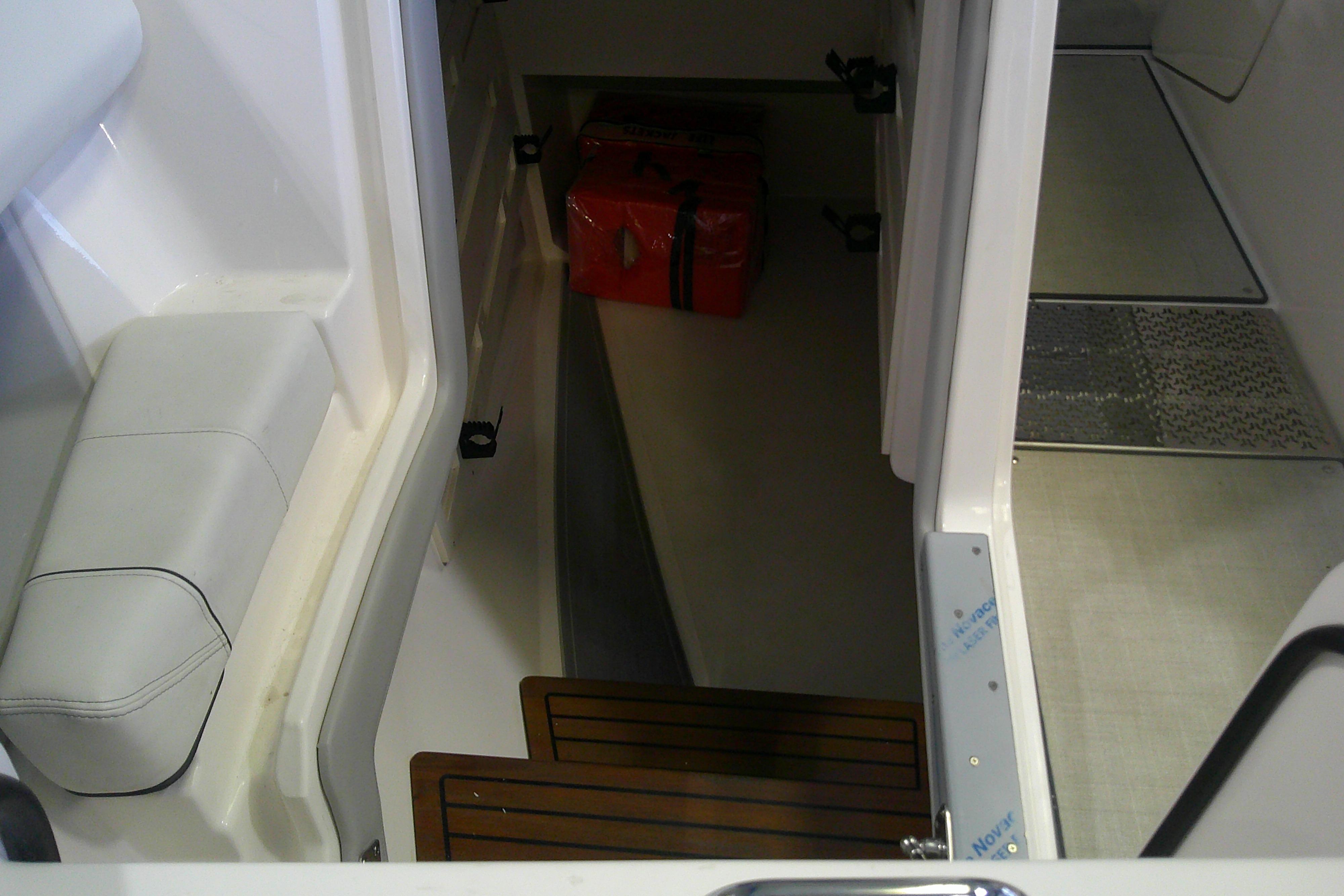 Interior view of 2023 Regal LX36 boat cabin with seating and storage area.