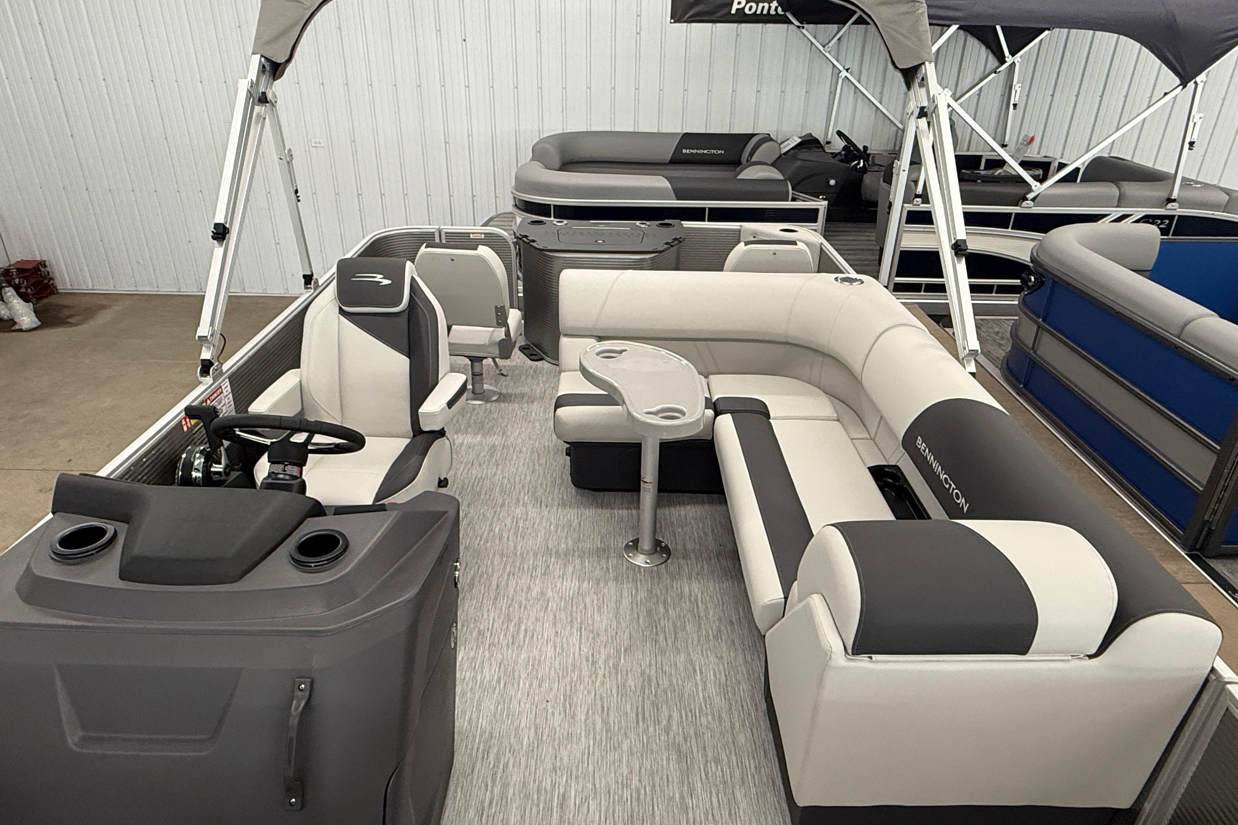 2026 Bennington 20 SF pontoon boat interior with gray and white seating and steering console.
