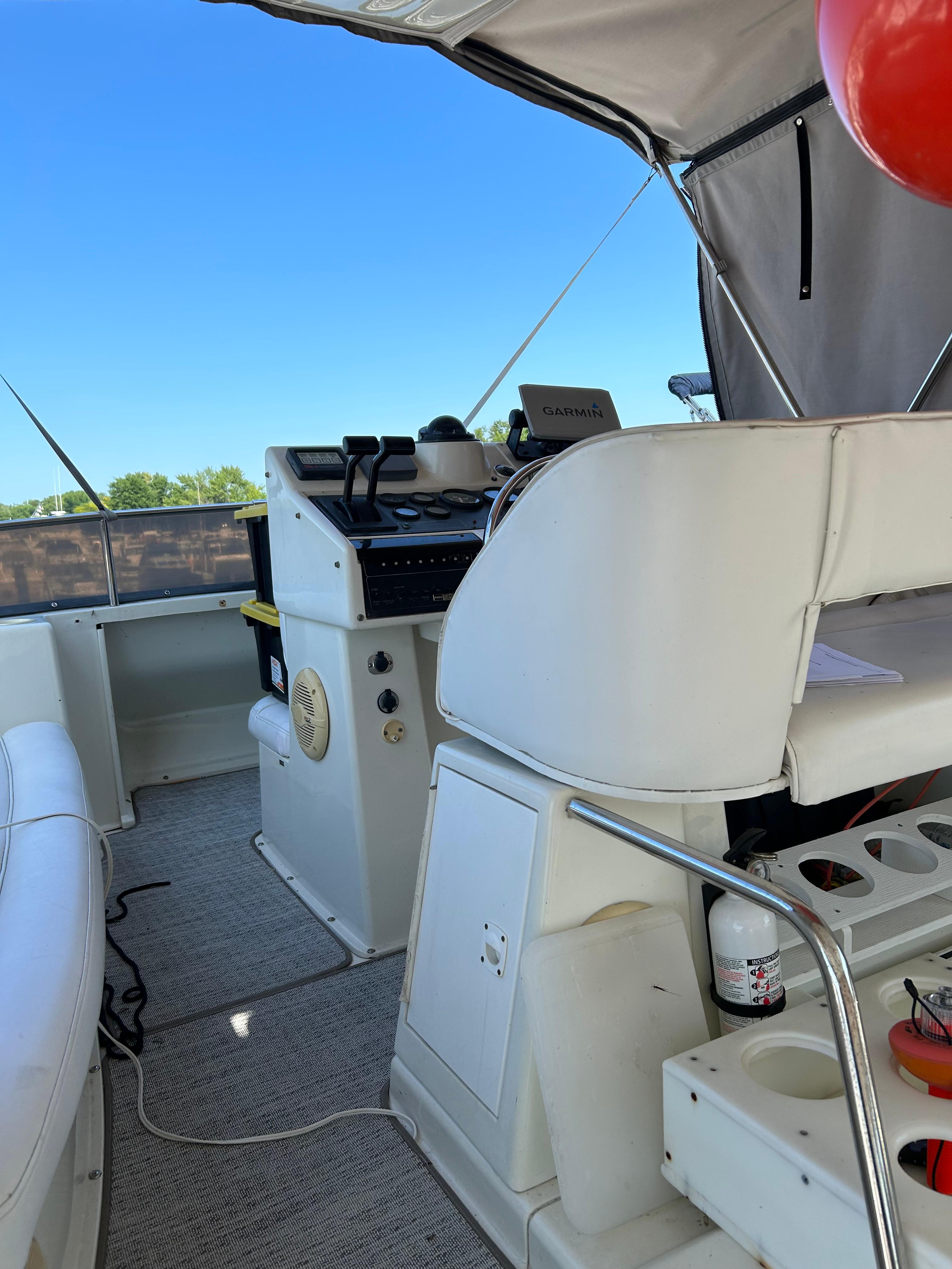 1995 Silverton AFT CABIN boat interior with helm, seating, and equipment under canopy.