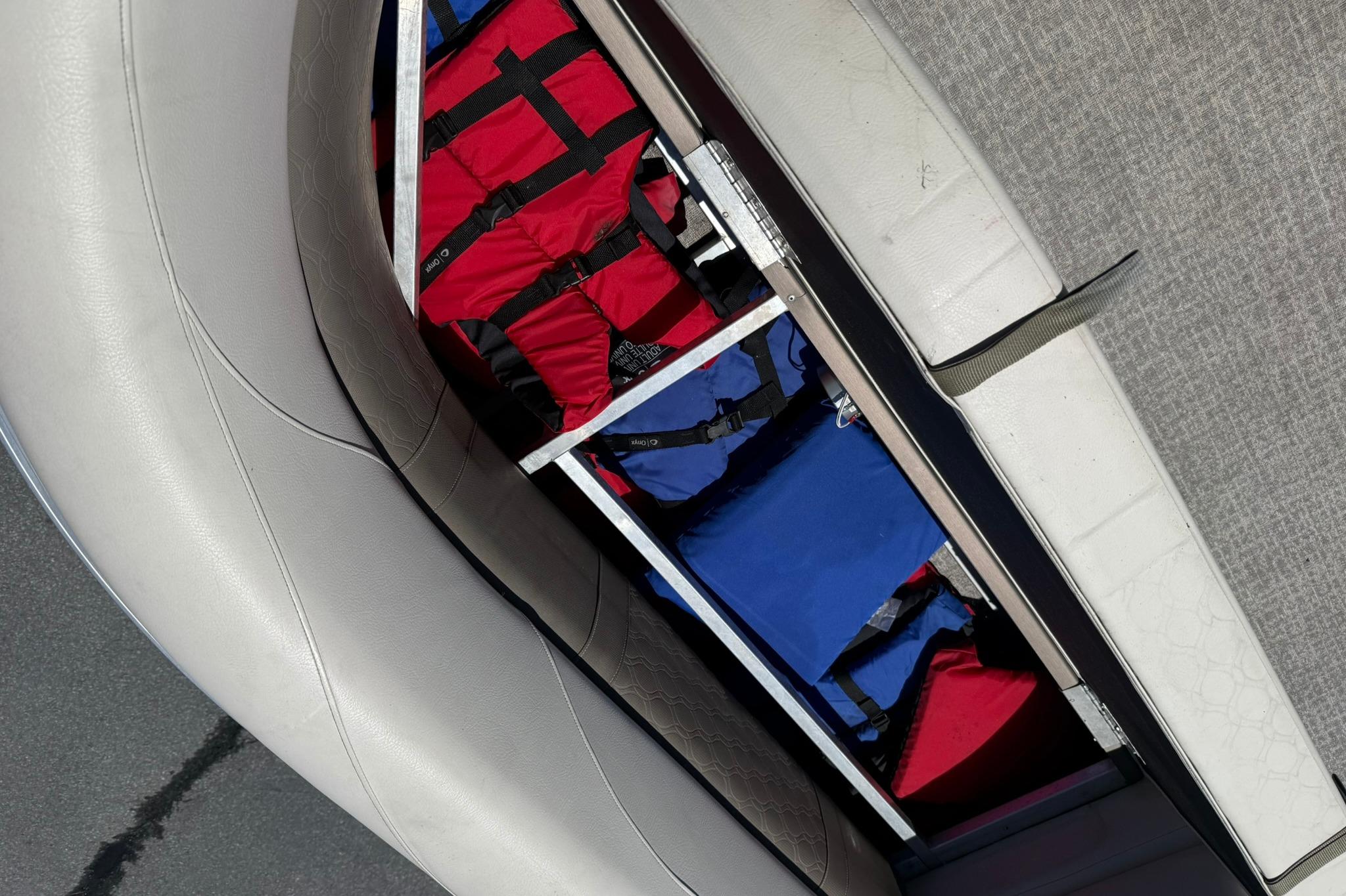 Storage compartment with life jackets on a 2019 Avalon GS Quad Lounge boat.