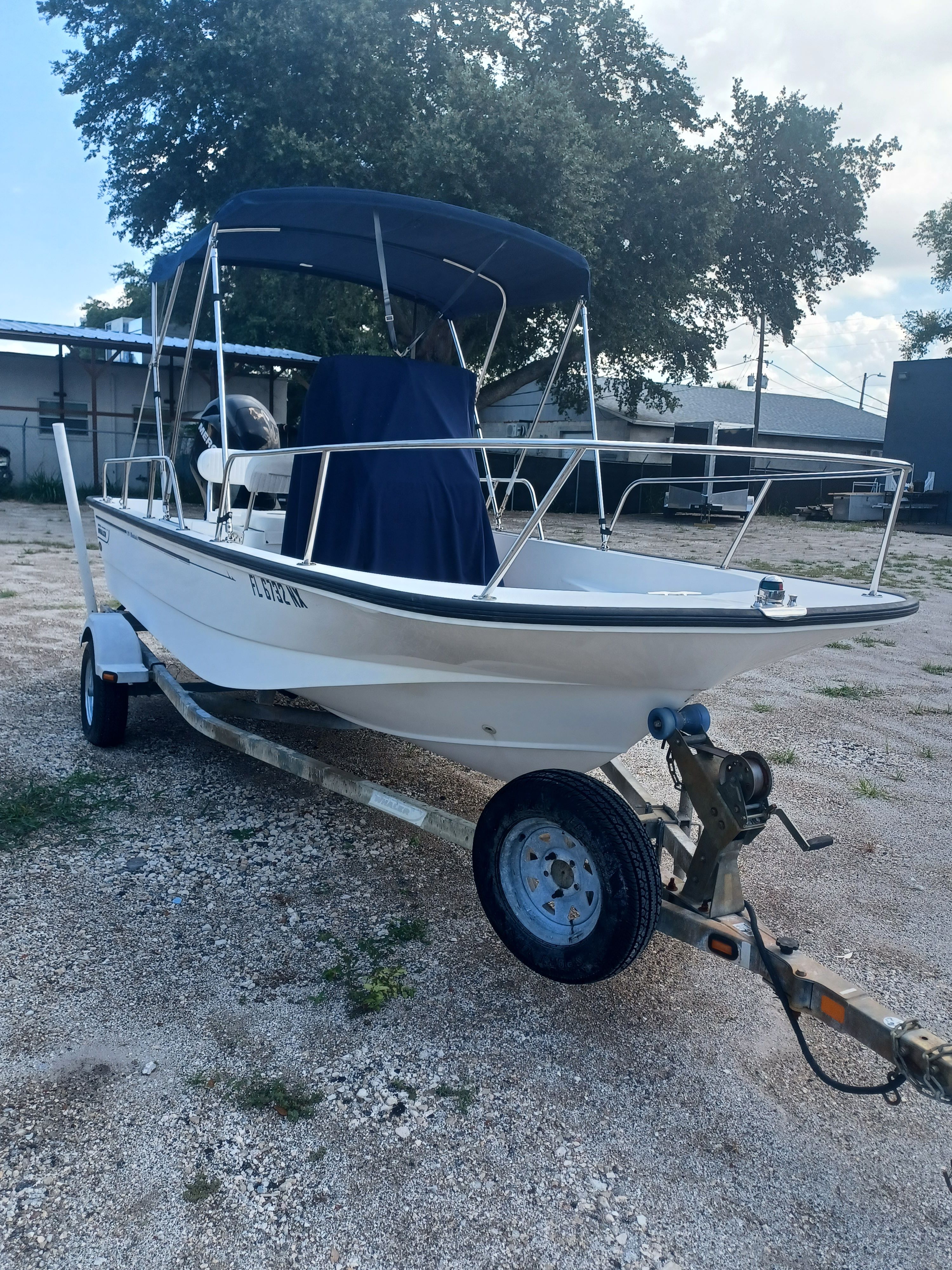 A 2008 Boston Whaler 170 Montauk on a trailer, featuring a blue cover and Bimini top.