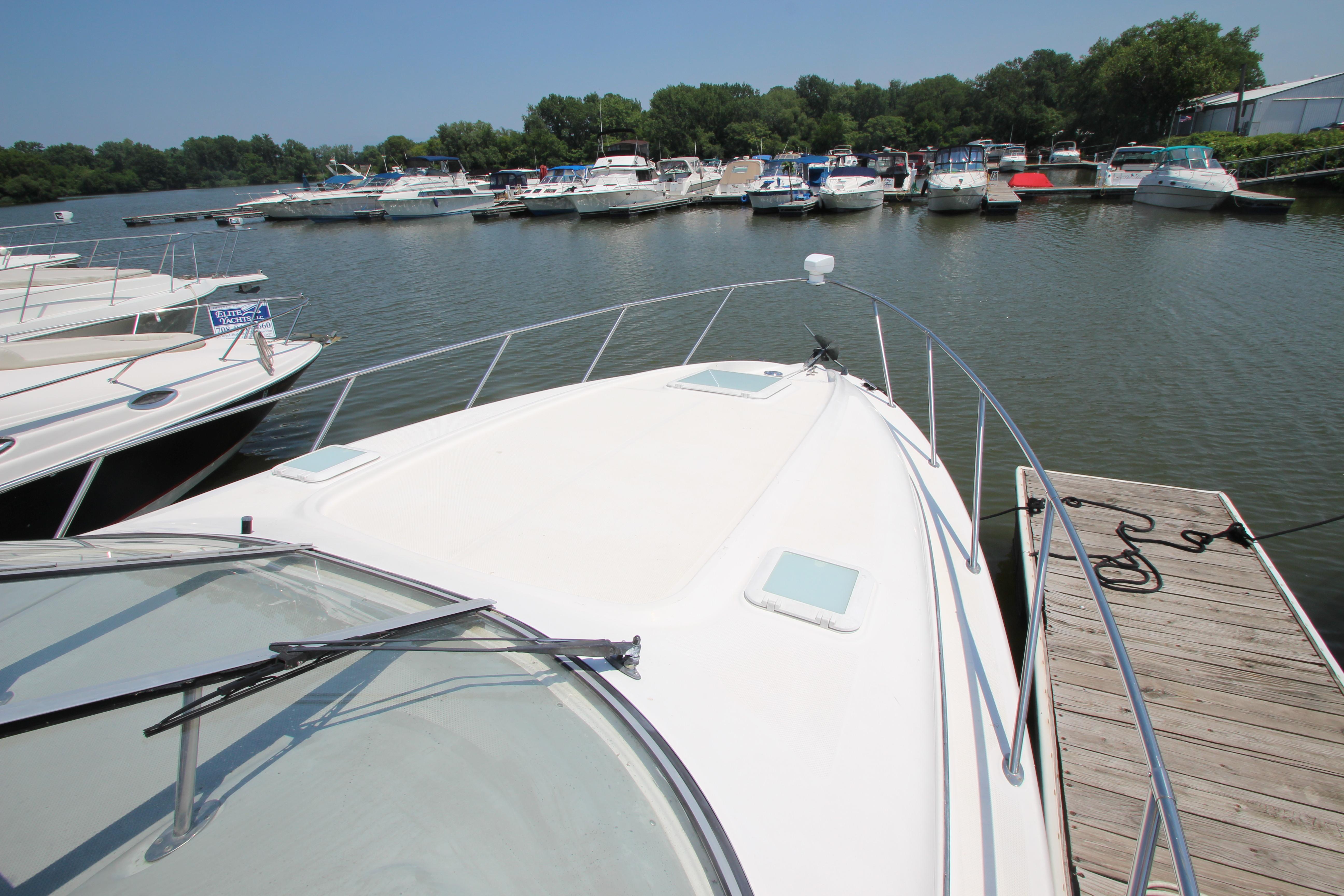 1999 Bayliner 3055 Ciera docked at marina, surrounded by other boats on a sunny day.