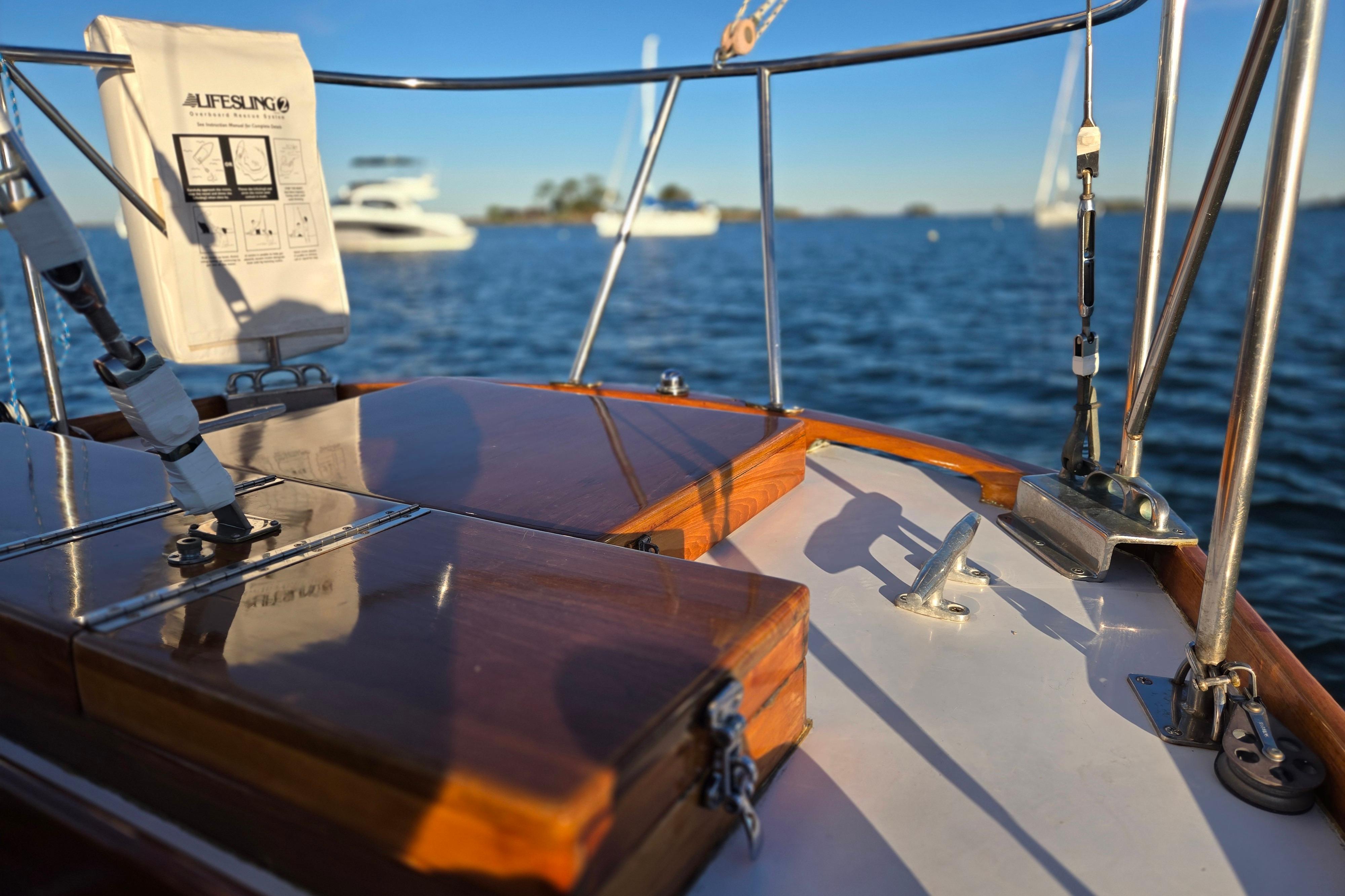 1970 Hinckley Bermuda 40 sailboat deck with polished wood and ocean view.