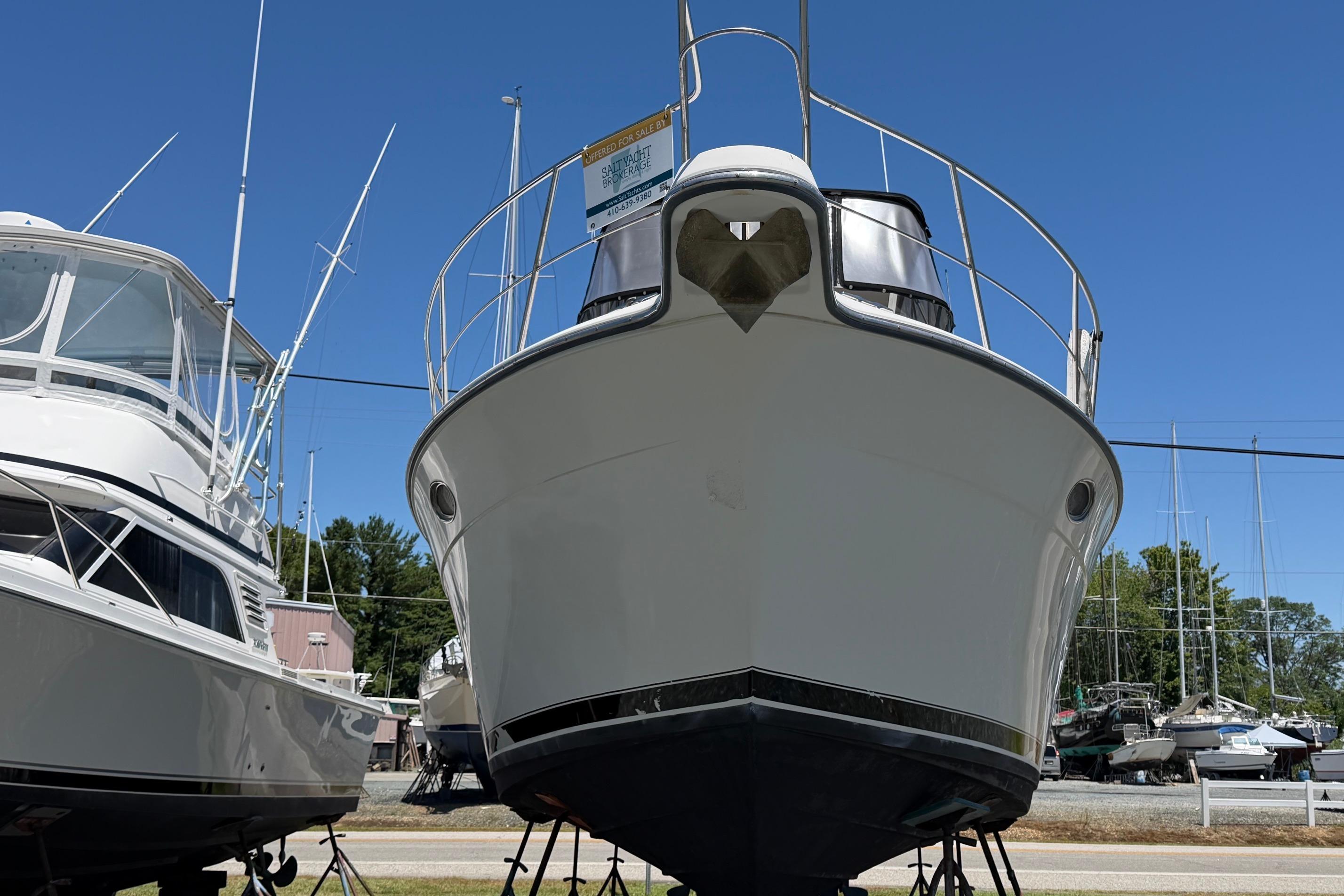 1995 Carver 356 Aft Cabin Motor Yacht on display in a marina under clear blue skies.