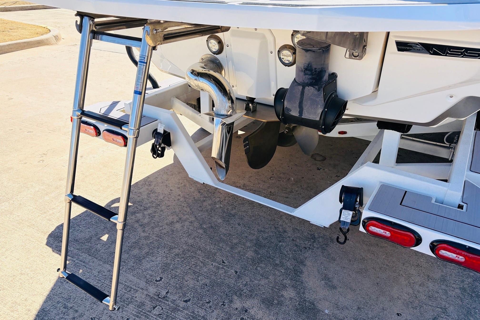 2023 Nautique Super Air Nautique G25 boat rear view with ladder and propeller.