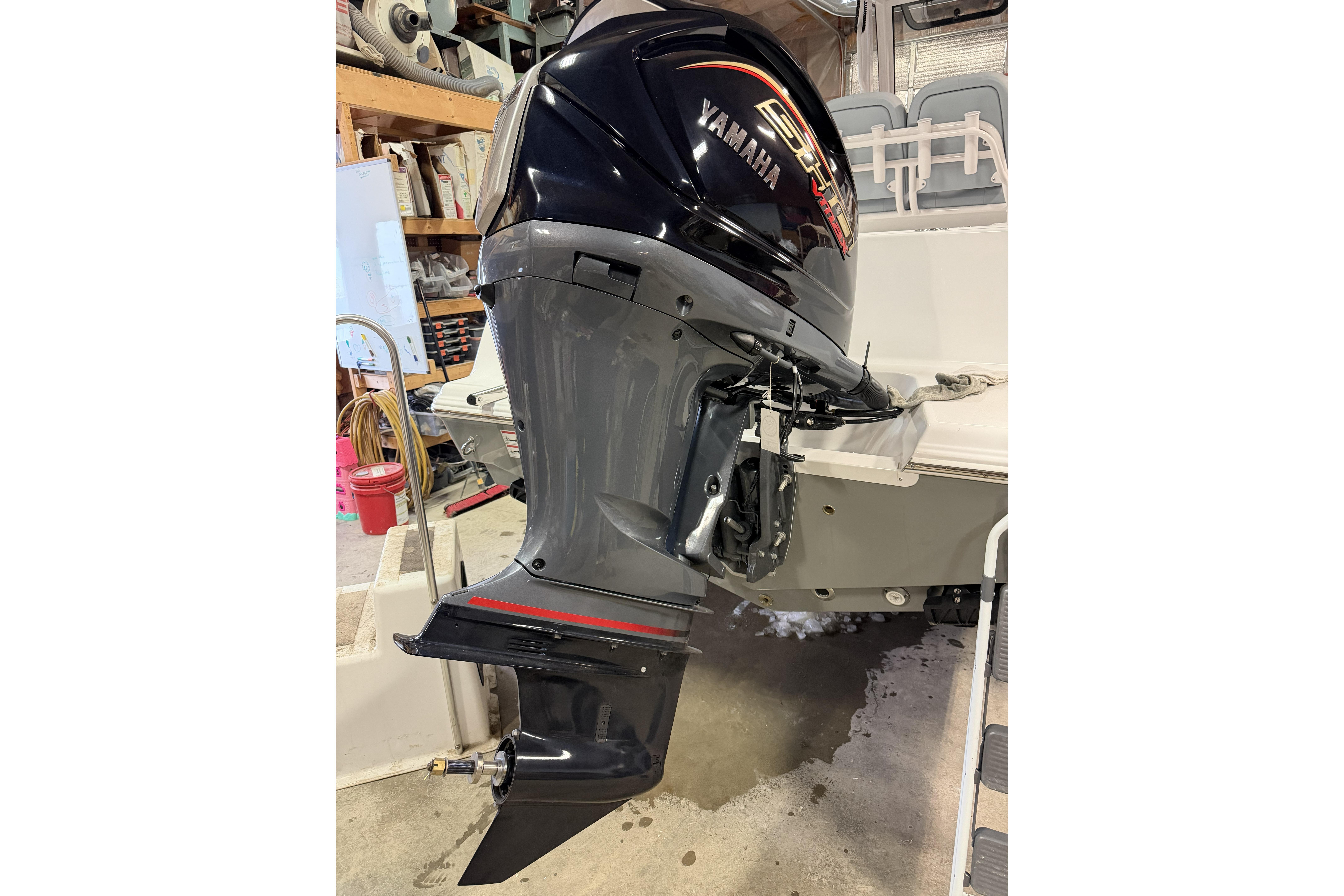 Yamaha outboard motor on 2026 Sportsman Open 232 Center Console boat in garage.