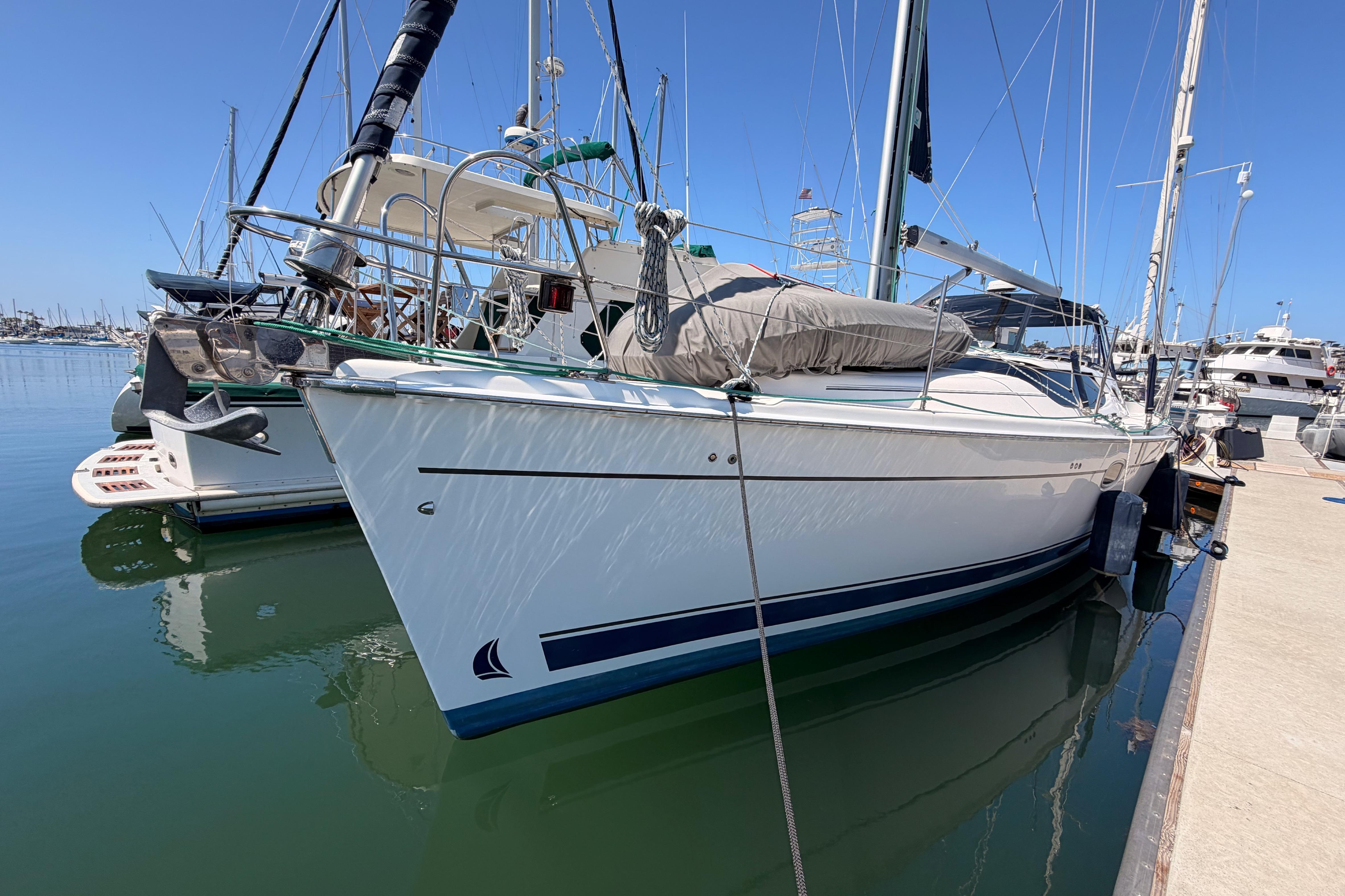 2008 Hunter 45 Deck Salon sailboat docked in a marina under clear blue skies.