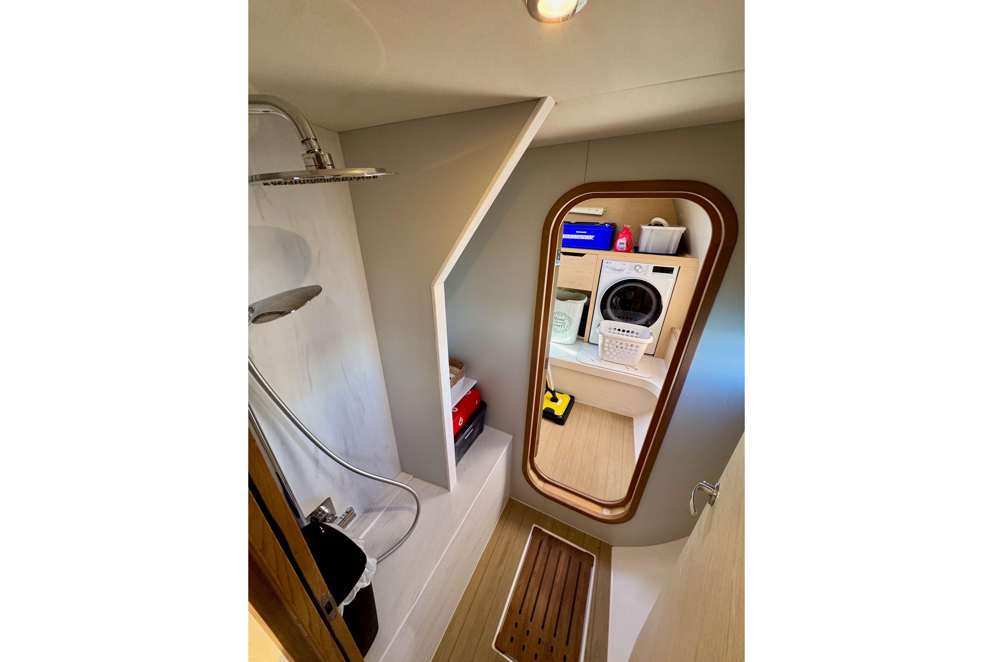 Modern bathroom and laundry area on 2023 NEEL 52 yacht, featuring shower and washing machine.