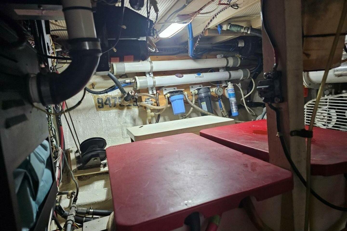 Engine room of 1985 Grand Banks 42 Classic yacht, featuring pipes and equipment.