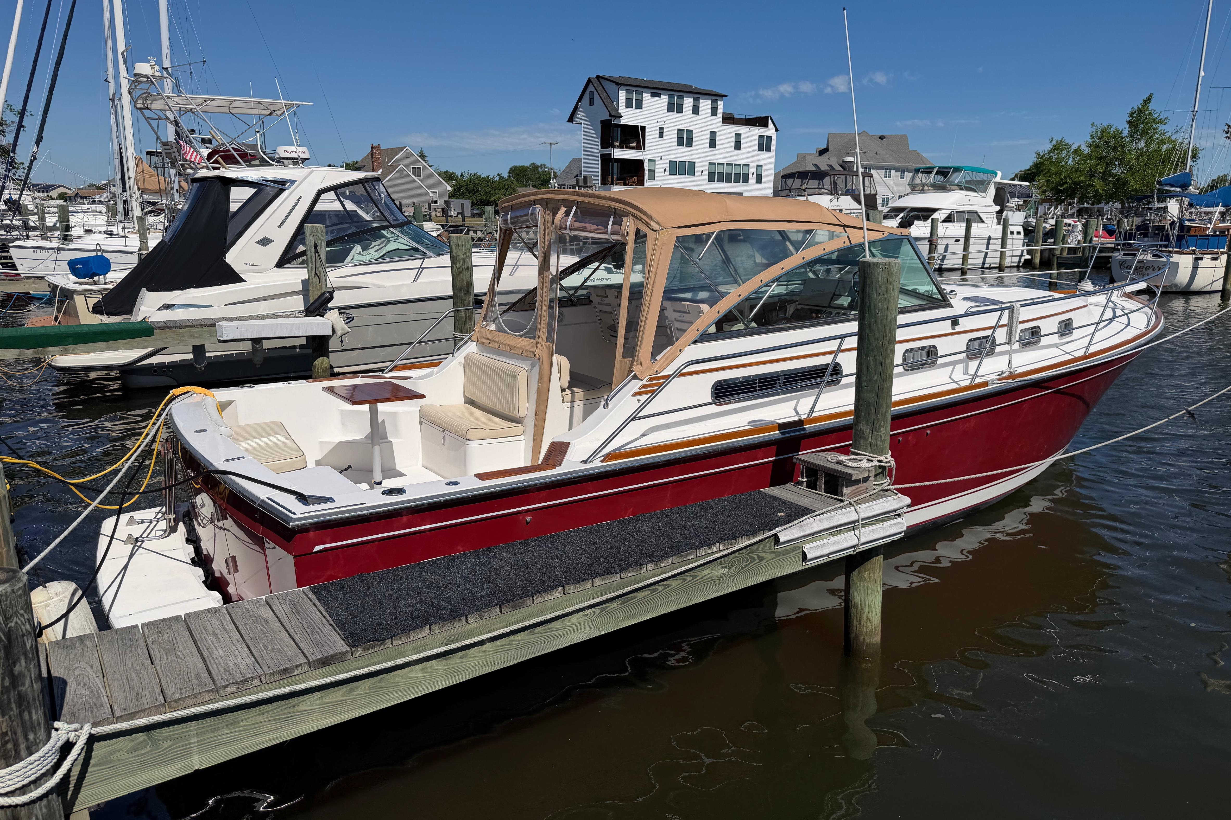 2000 Sabreline 36 Express boat docked at a marina under clear blue skies.