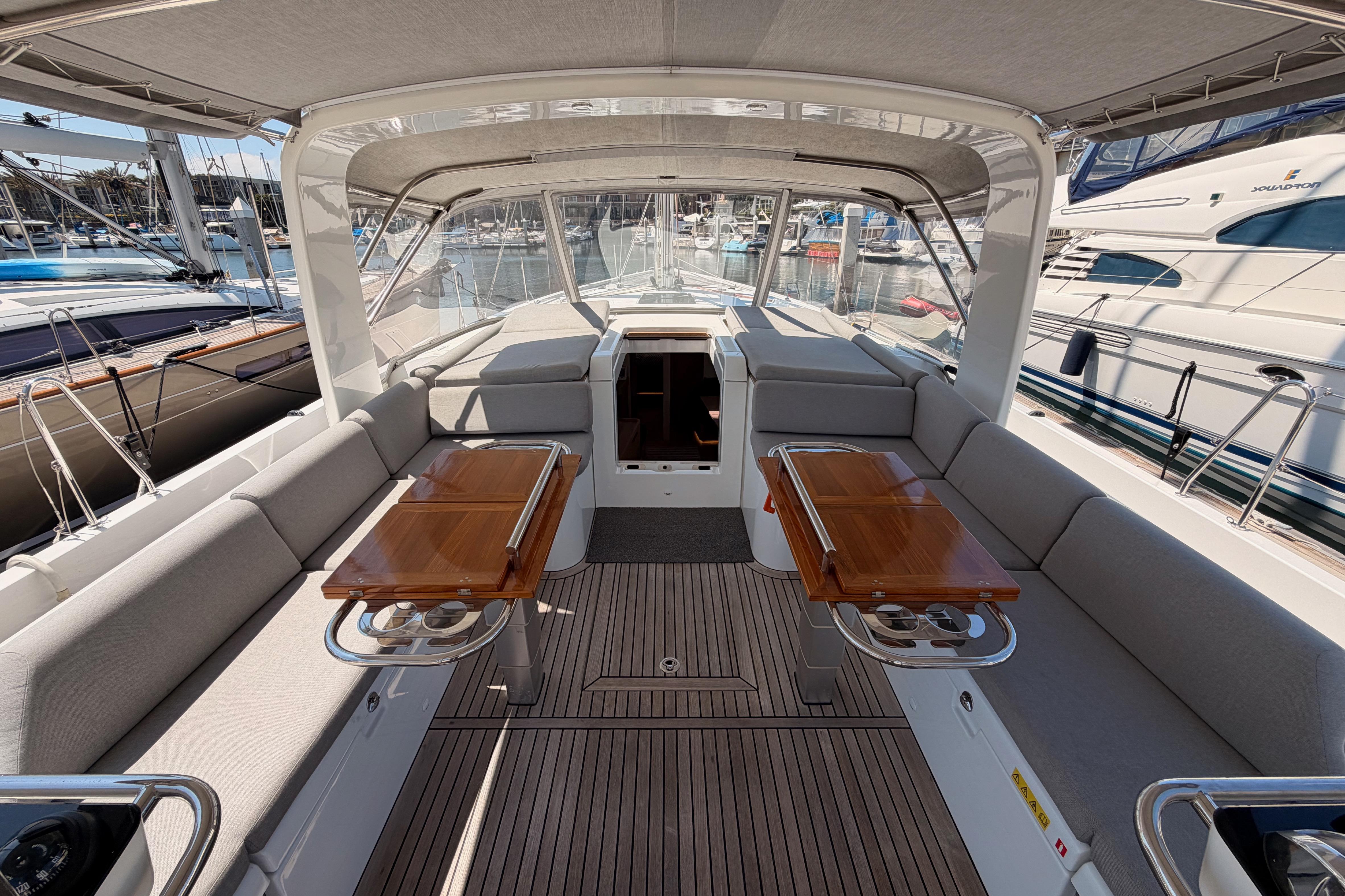 Luxurious 2022 Beneteau Oceanis Yacht 54 cockpit with elegant seating and wooden tables.