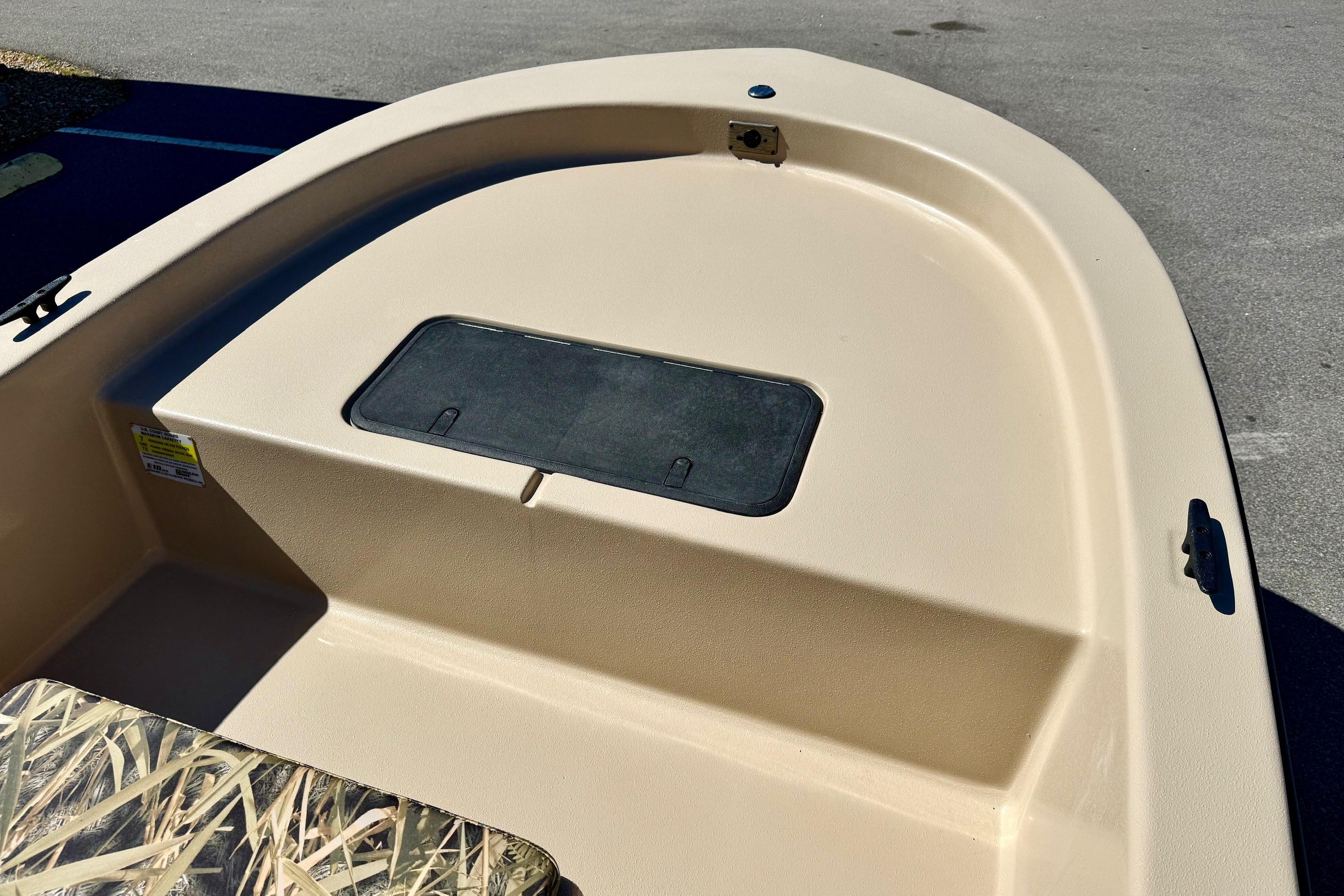 2026 Carolina Skiff E18 JVX CC boat deck with storage compartment, beige finish.