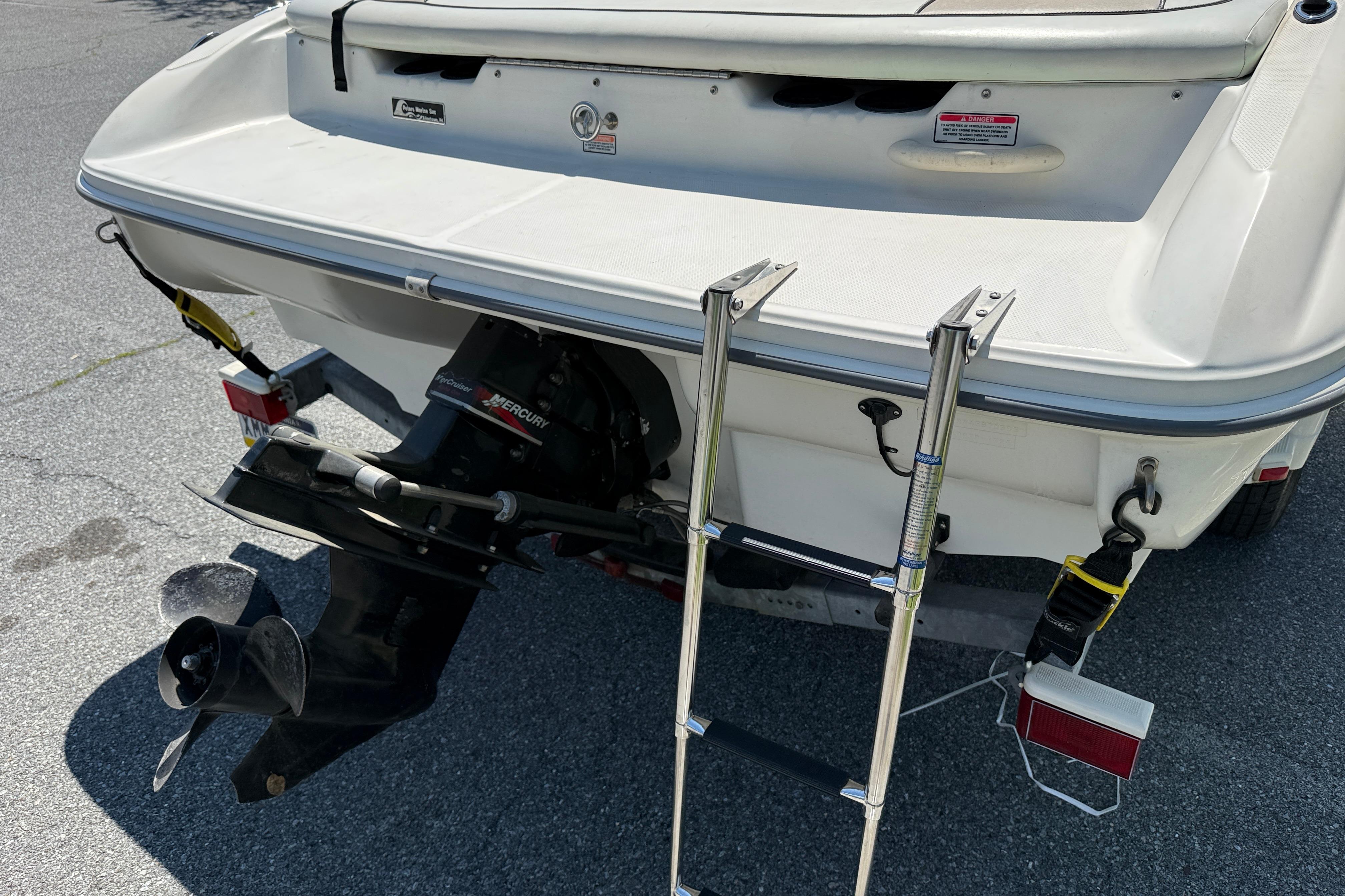 Rear view of a 2003 Sea Ray 182 Bow Rider boat with ladder and Mercury outboard.