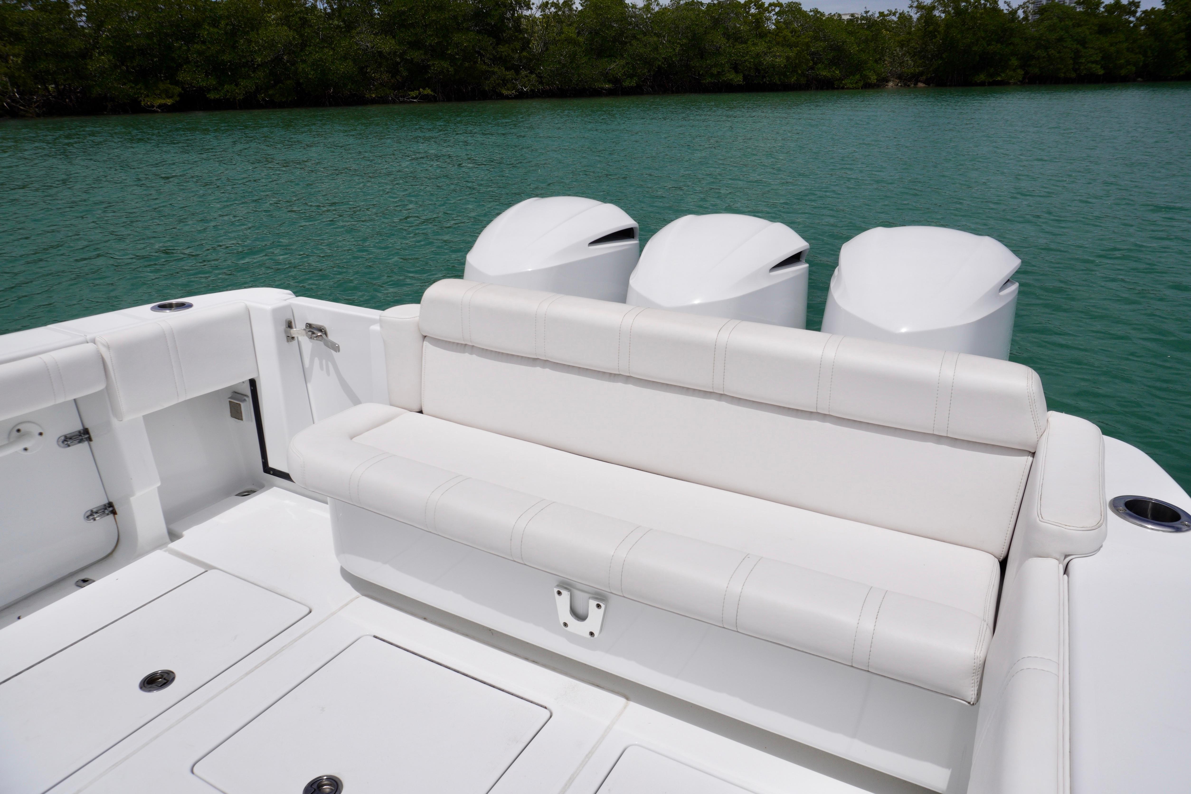 2013 Contender 35 LS boat with triple engines and white seating on calm water.