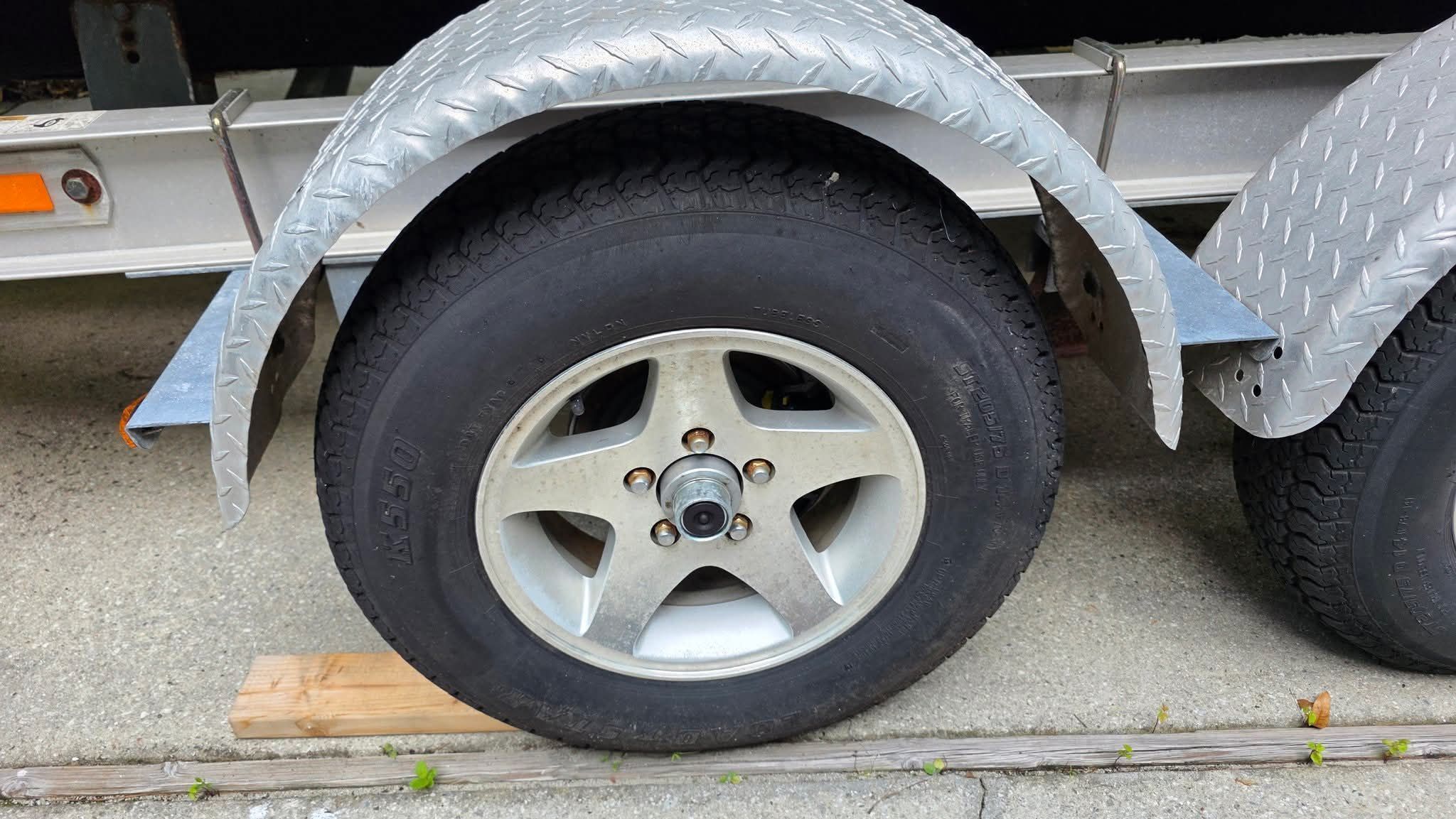 Close-up of a boat trailer wheel with metal fender.