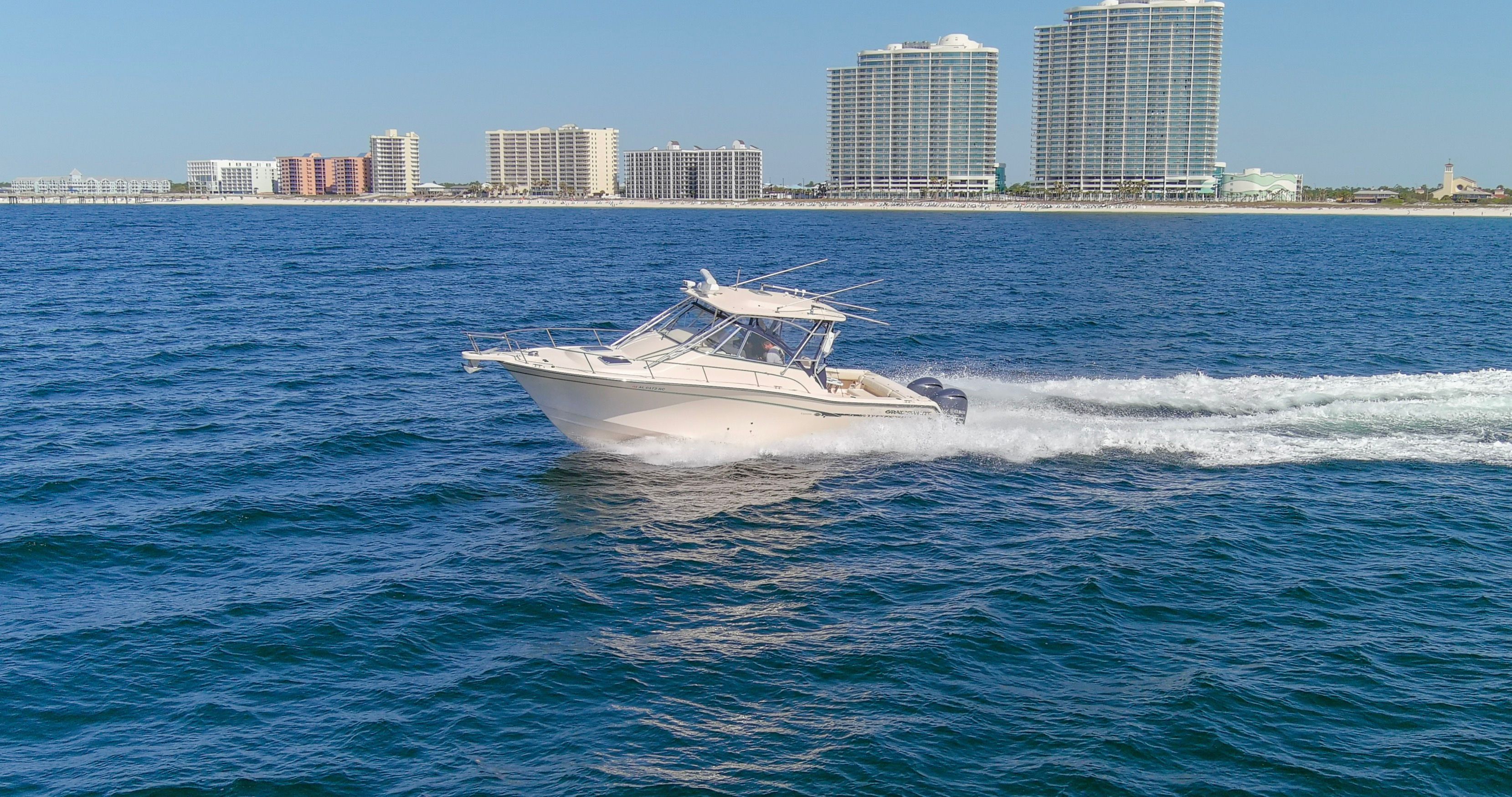 2009 Grady-White Express 330 boat on the ocean near skyscrapers.