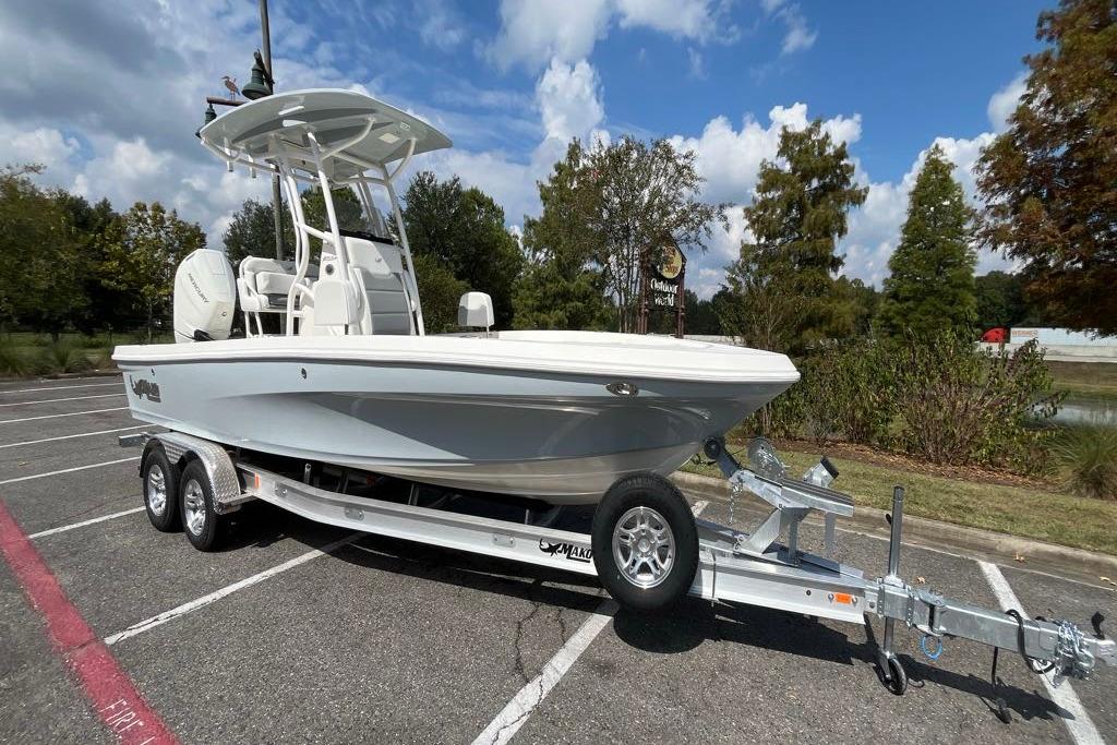 2026 Mako 24 APEX boat on trailer in parking lot, under clear sky.