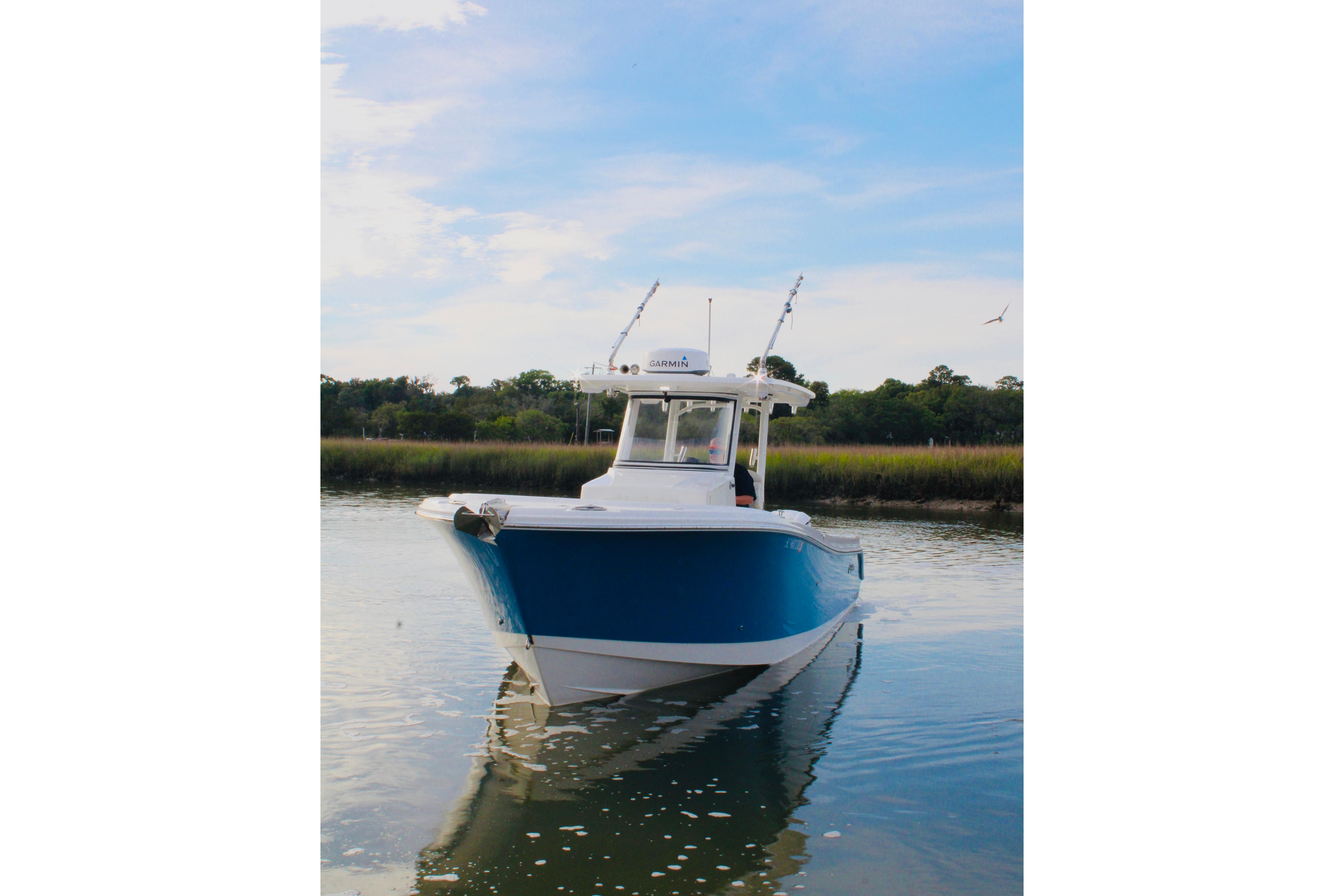 2022 Edgewater 280CC boat on calm water with blue sky background.