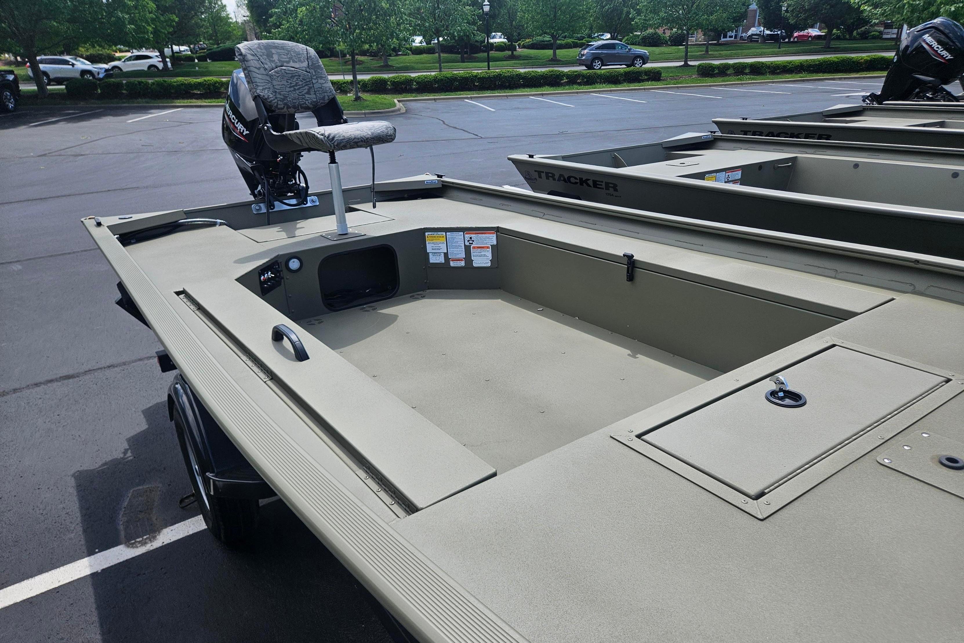2026 Tracker Grizzly 1654 T Sportsman boat in parking lot, showcasing spacious interior.