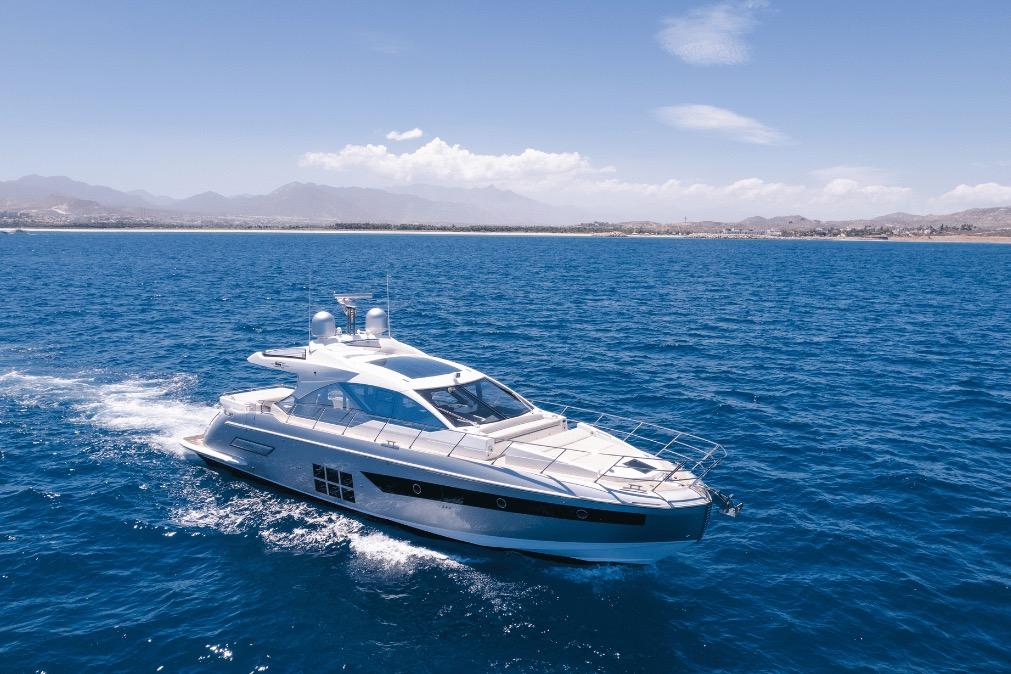 Luxury 2020 Azimut 60 yacht cruising on open blue sea under clear sky.