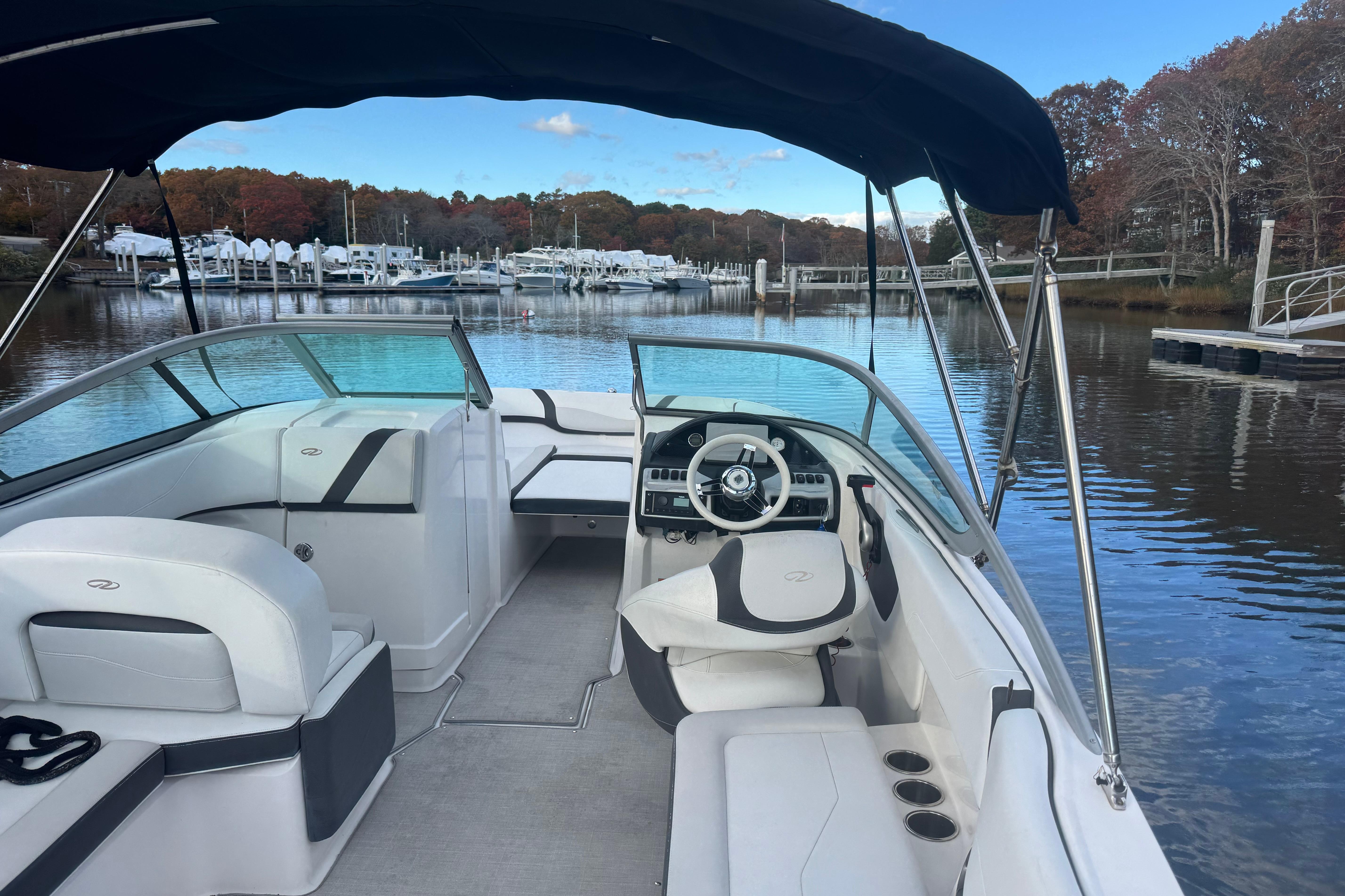 2017 Regal 23 OBX boat interior with steering wheel, docked in a serene marina.