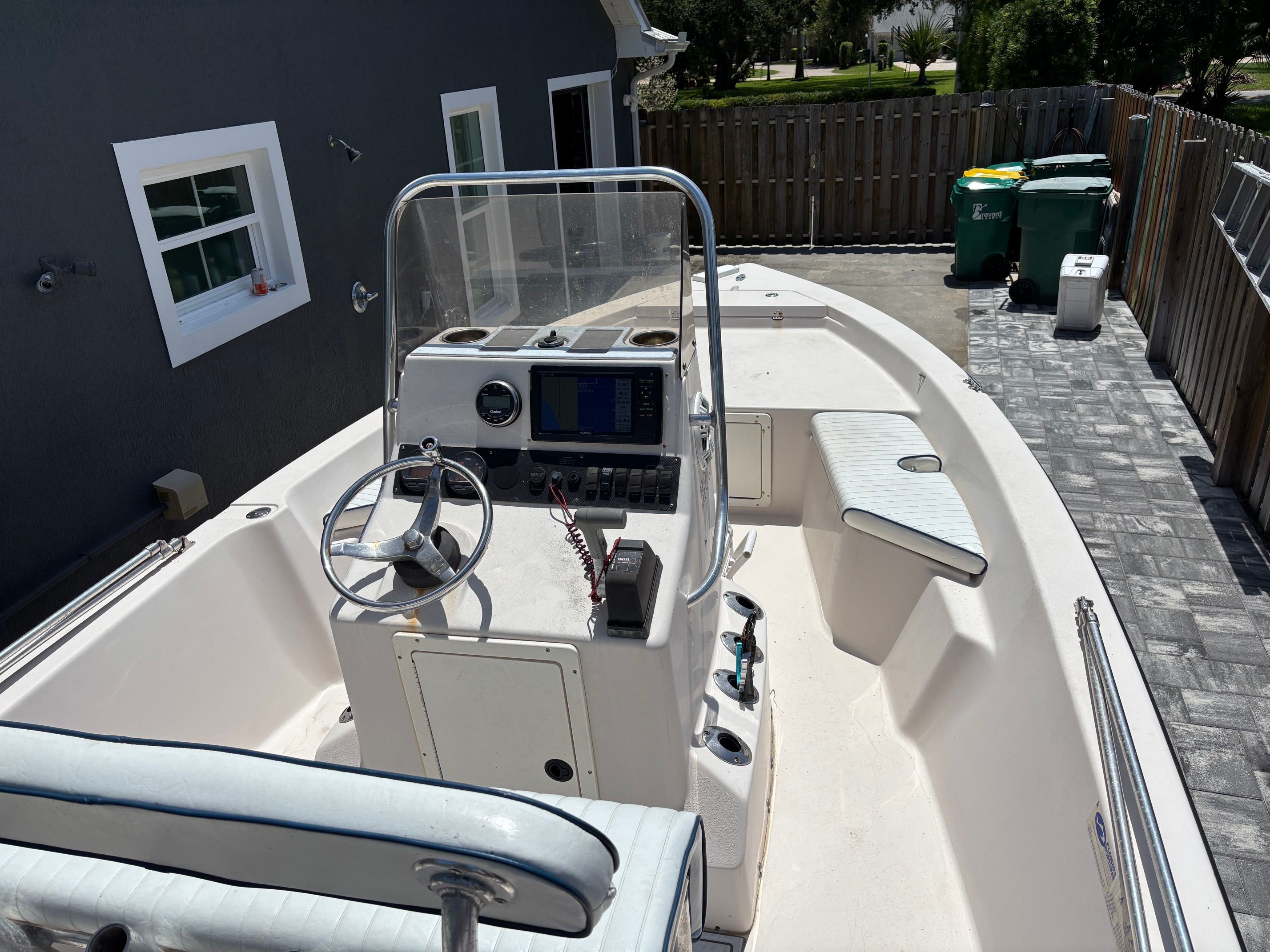 The image shows a 2003 Pathfinder 1900T boat. It is situated in a driveway.