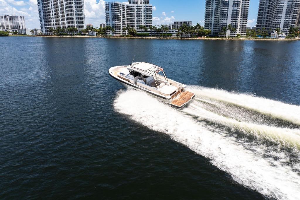 2021 Bluegame BG 42 yacht cruising on water near city skyline.