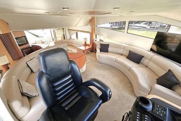 Luxurious interior of a 2005 Sunseeker Manhattan 66 yacht with plush seating and helm chair.