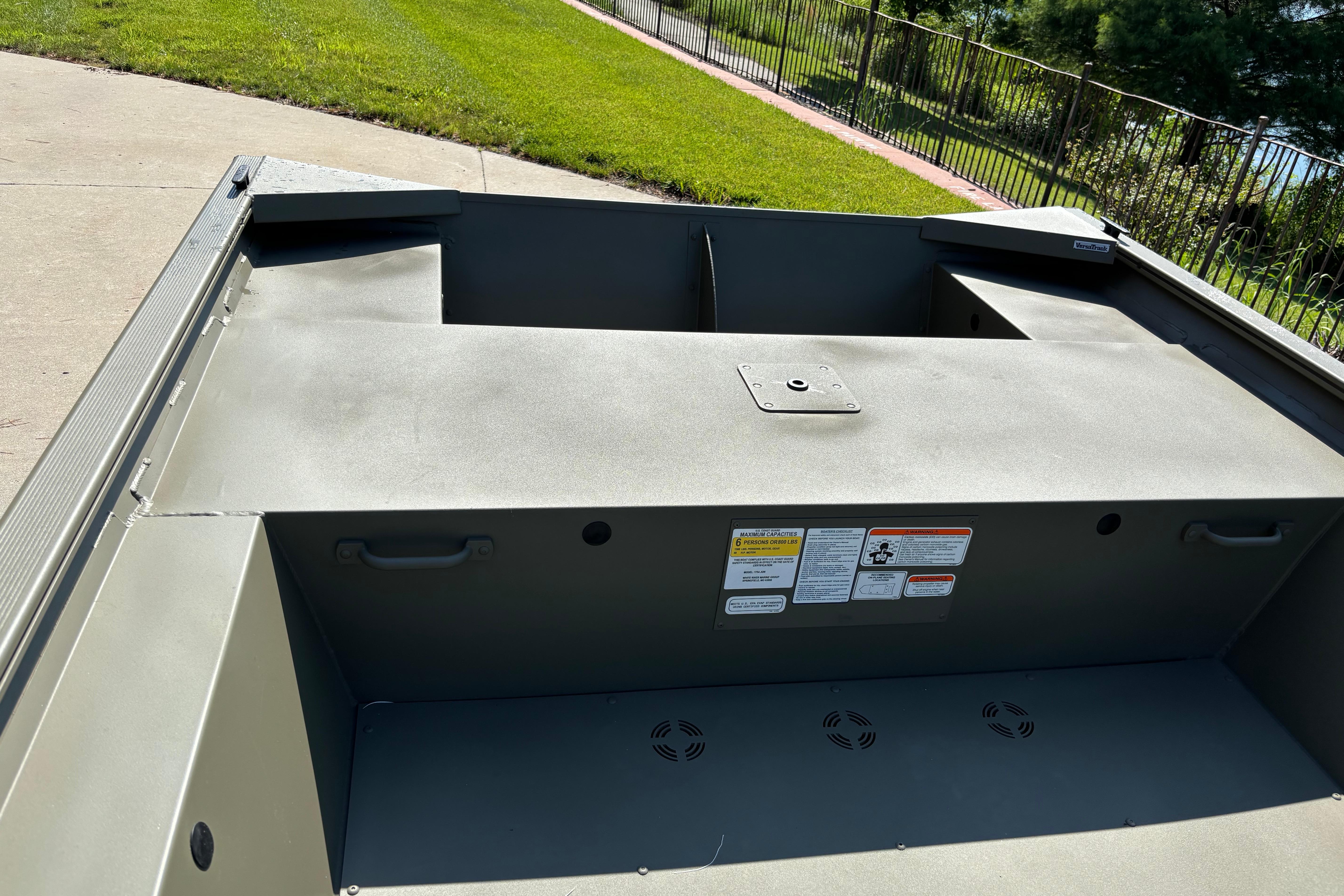 2026 Tracker Grizzly 1754 Utility boat interior with storage compartments and safety labels.
