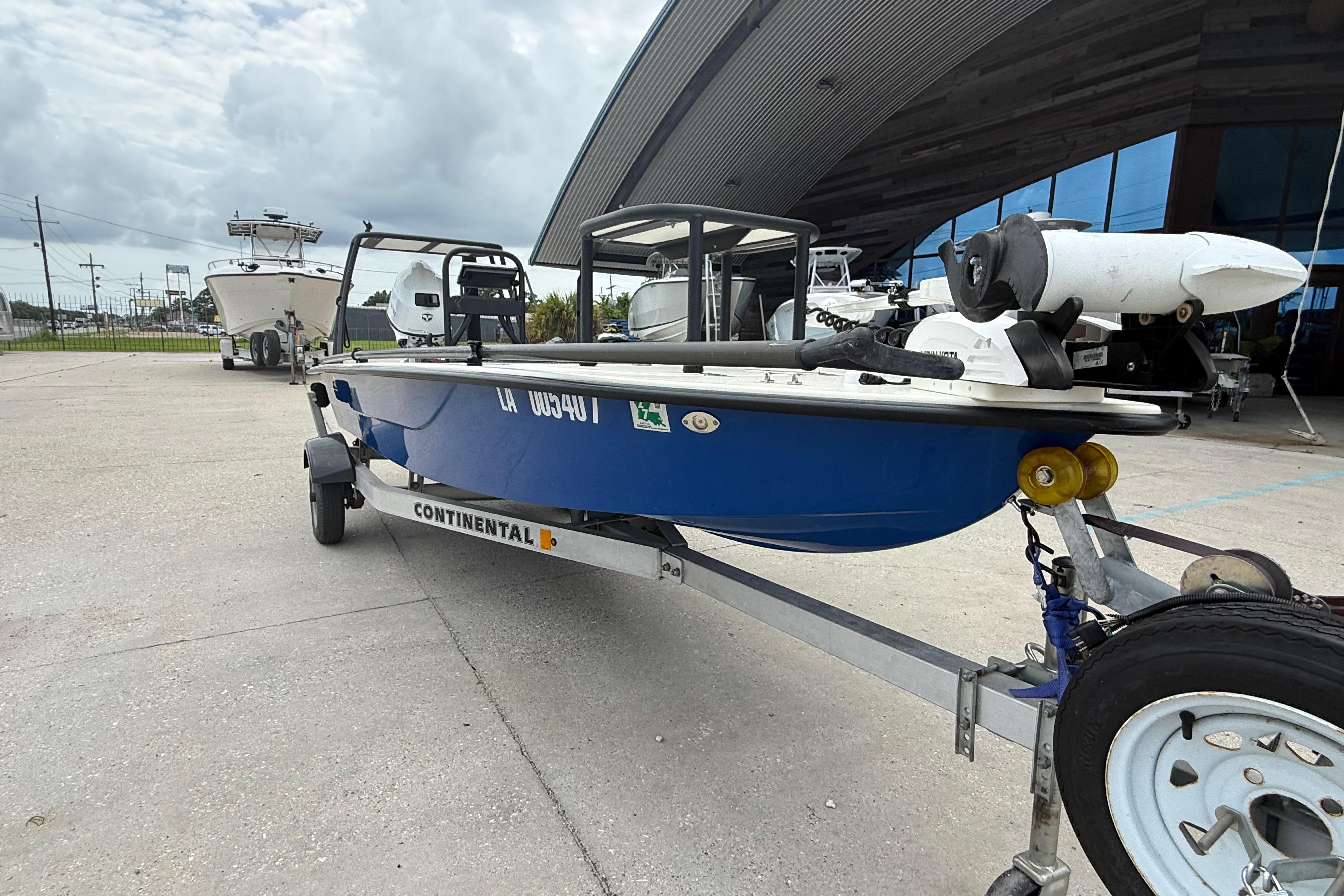 2020 Skimmer Skiff 14 boat on trailer, parked outside a modern building.