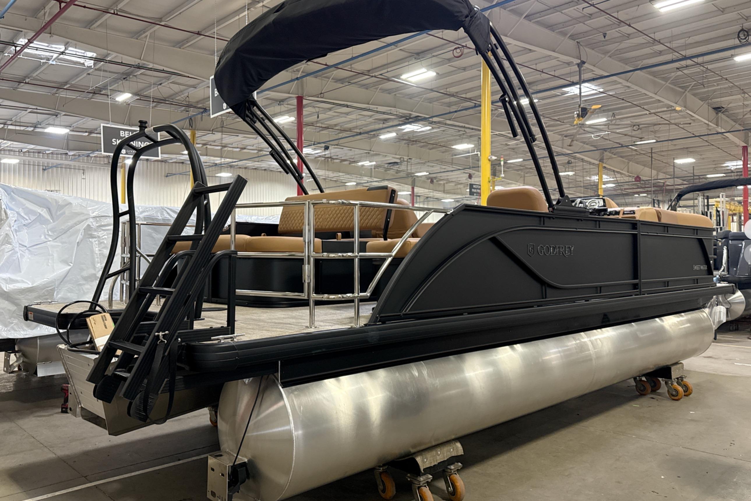 2026 Godfrey Sweetwater 22' Tritoon boat in a warehouse, featuring a single flip lounge.
