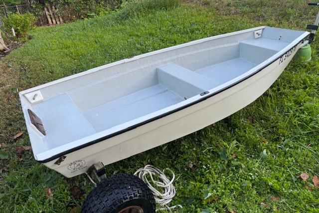 1999 Beacon Boats Pram on grassy area, featuring a simple white design and sturdy construction.