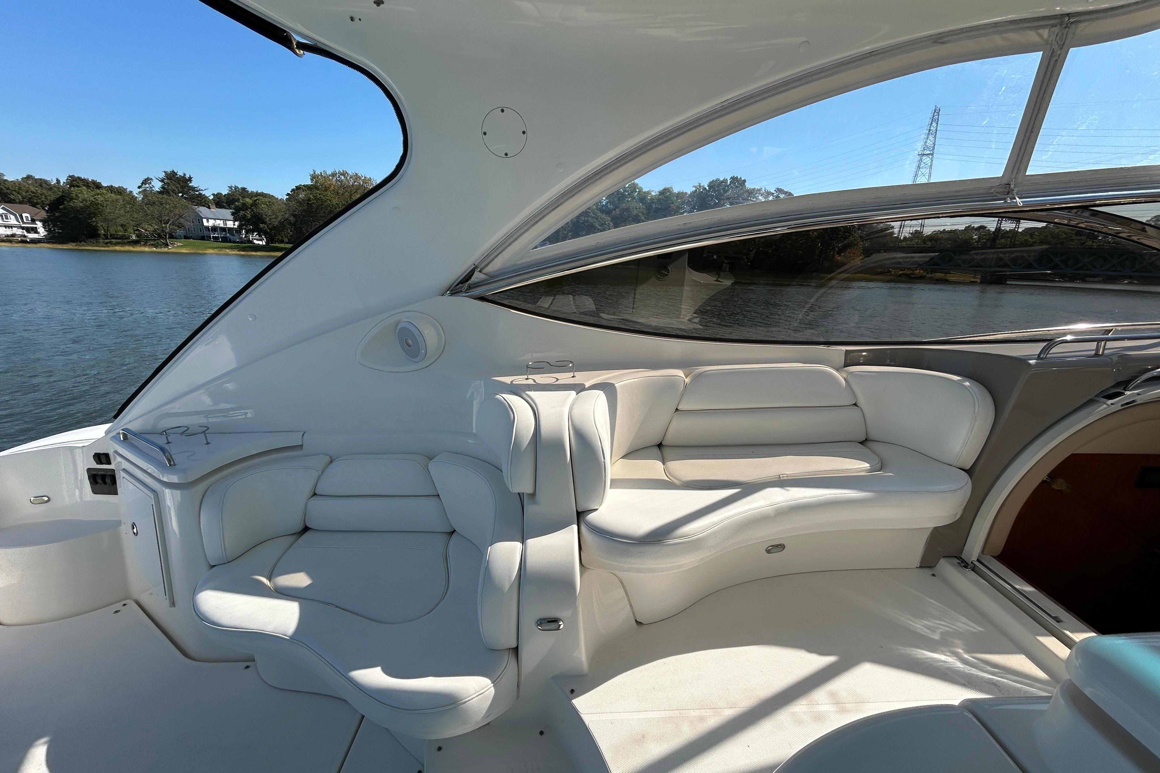 Luxurious 2003 Cruisers Yachts 540 Express interior with elegant white seating and scenic water view.
