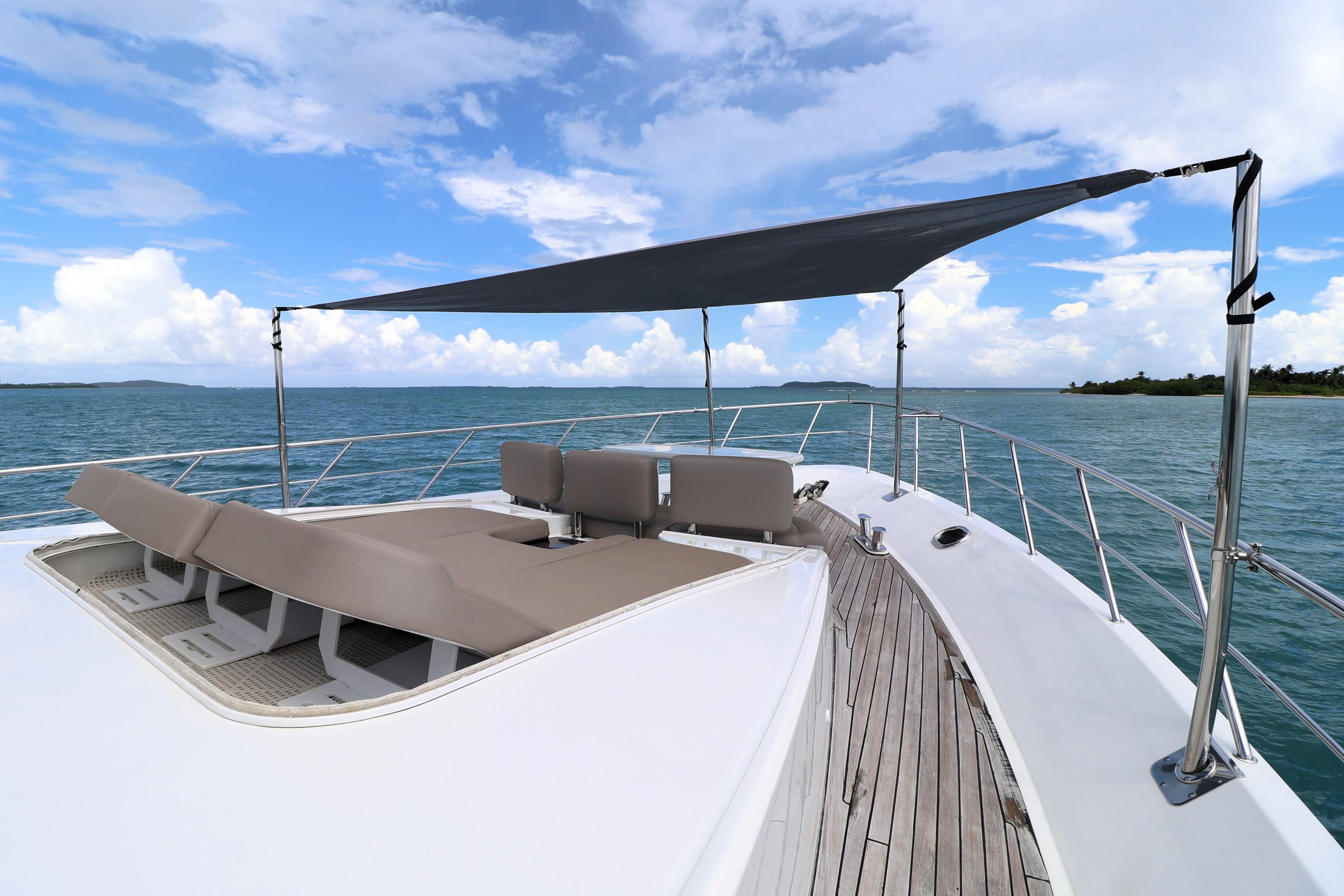 2013 Cheoy Lee Bravo yacht deck with sunshade and lounge chairs on open water.