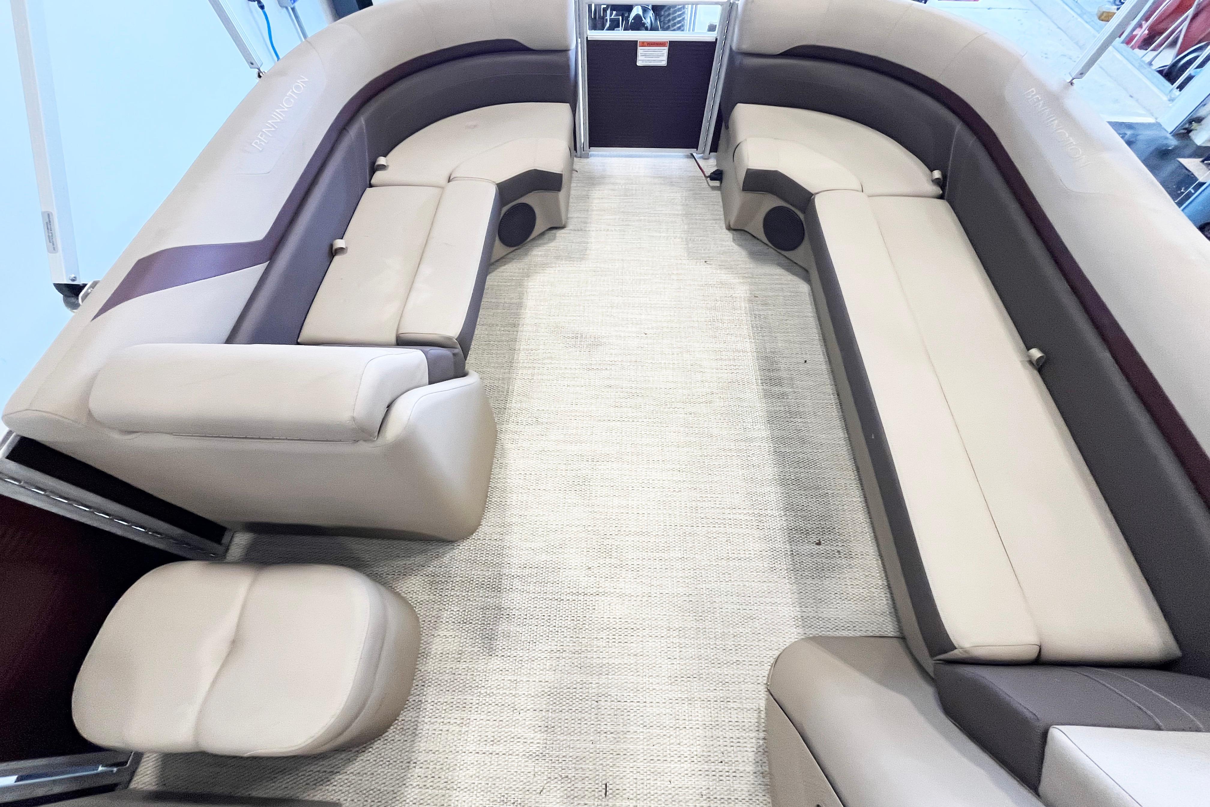 2020 Bennington SX25 pontoon boat interior with beige seating and carpet flooring.