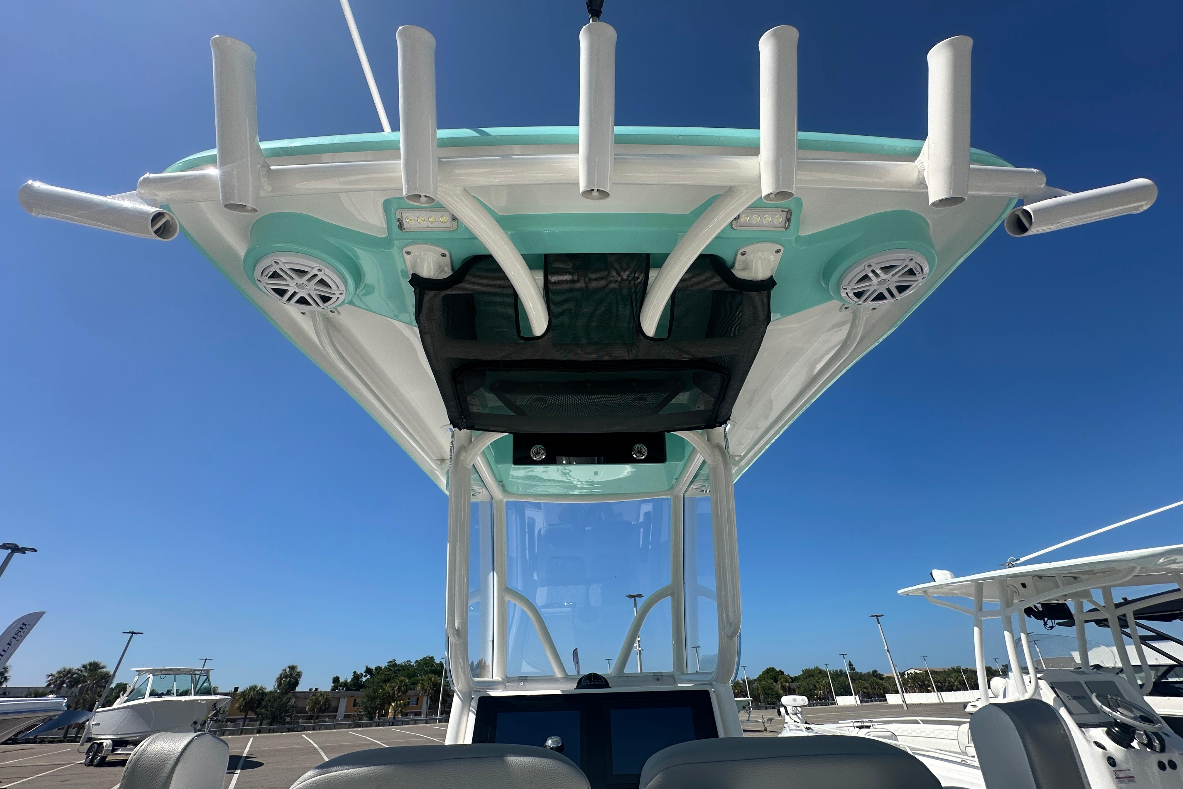 2021 Caymas 28 HB boat with rod holders and speakers under a clear blue sky.