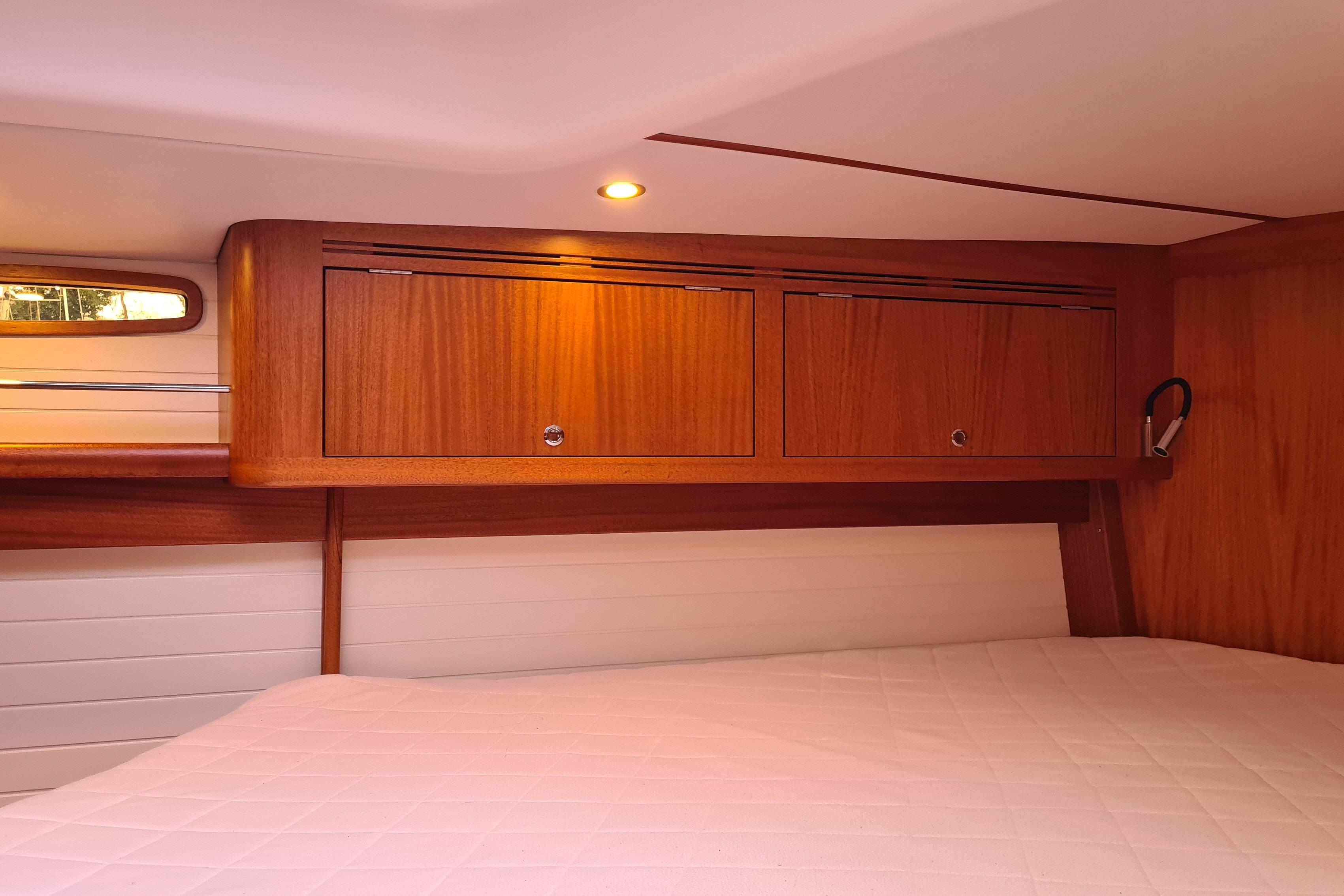 Luxurious cabin interior of 2018 Arcona 435 yacht with wooden cabinetry and cozy lighting.