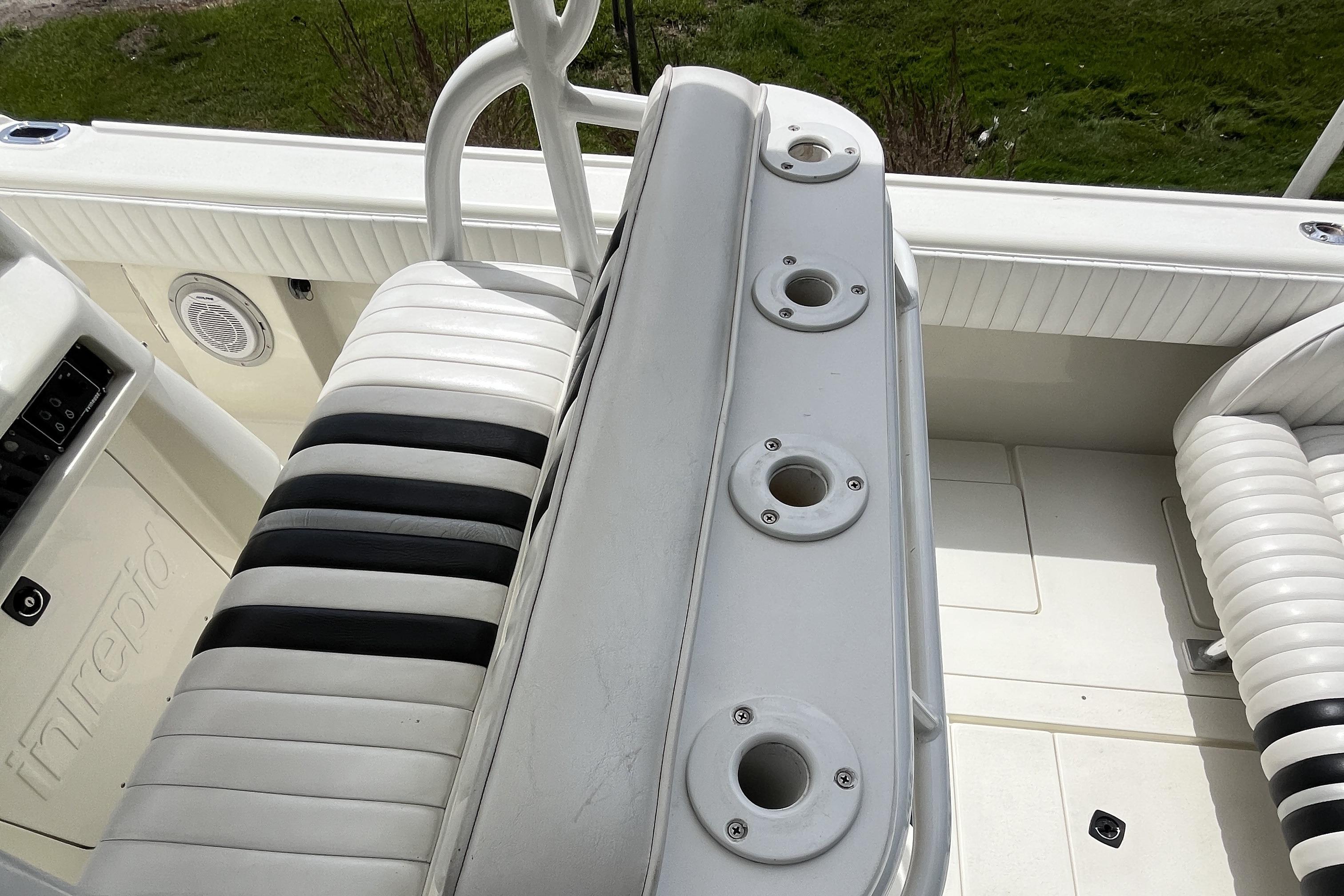 1994 Intrepid 30 Open Cuddy boat interior with white and black seating and rod holders.
