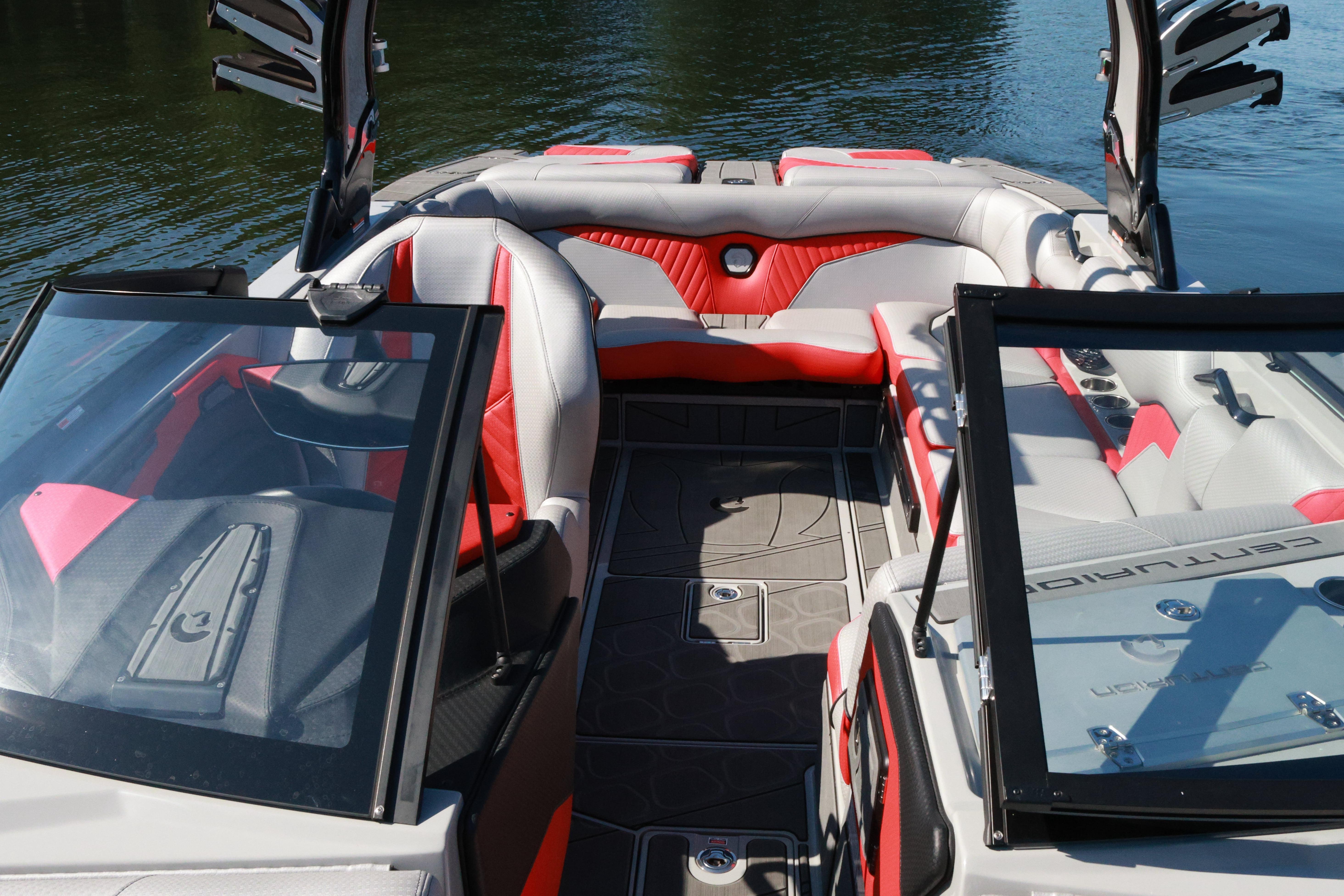 2024 Centurion Fi23 boat interior with red and gray seating, open windshield, on calm water.