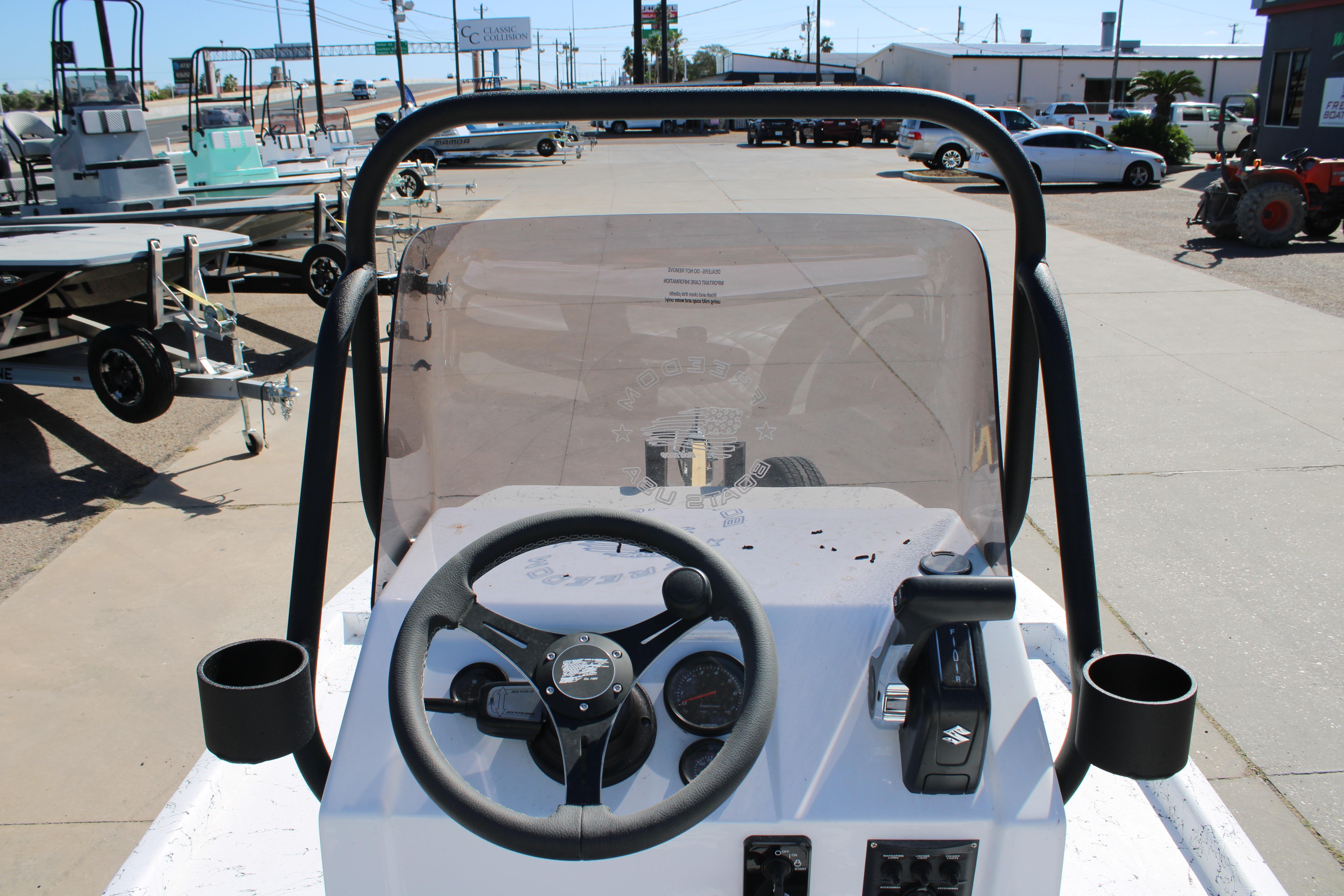 2026 Freedom Boats Chiquita dashboard with steering wheel and controls, outdoor display.