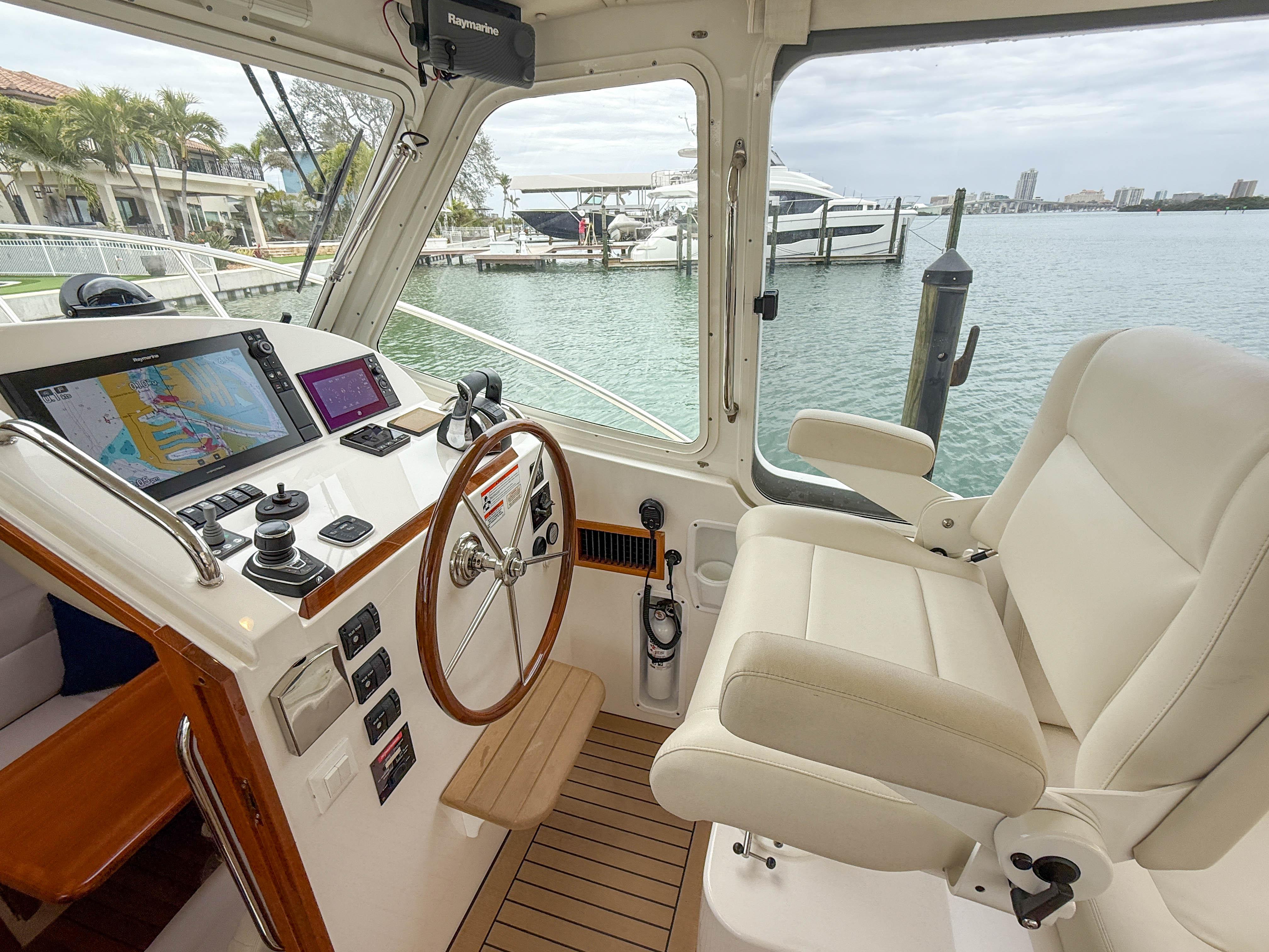 Helm of 2019 MJM 43z yacht with navigation equipment and luxurious seating.