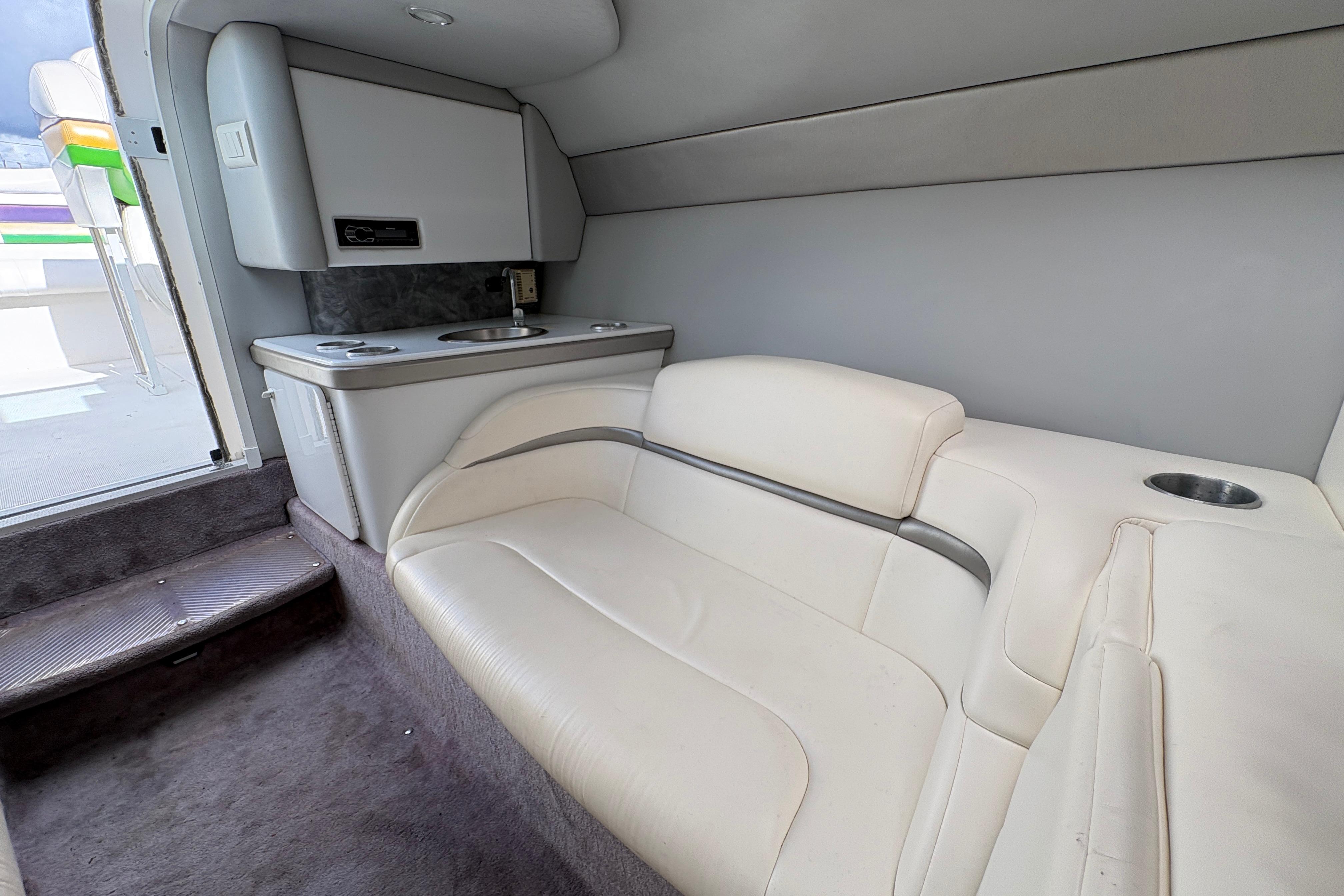 Interior of 2002 Formula 292 FASTech boat with white seating and compact kitchenette.