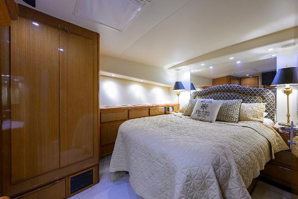 Luxurious bedroom interior of 2000 Viking 50 Convertible yacht with elegant bedding and lighting.