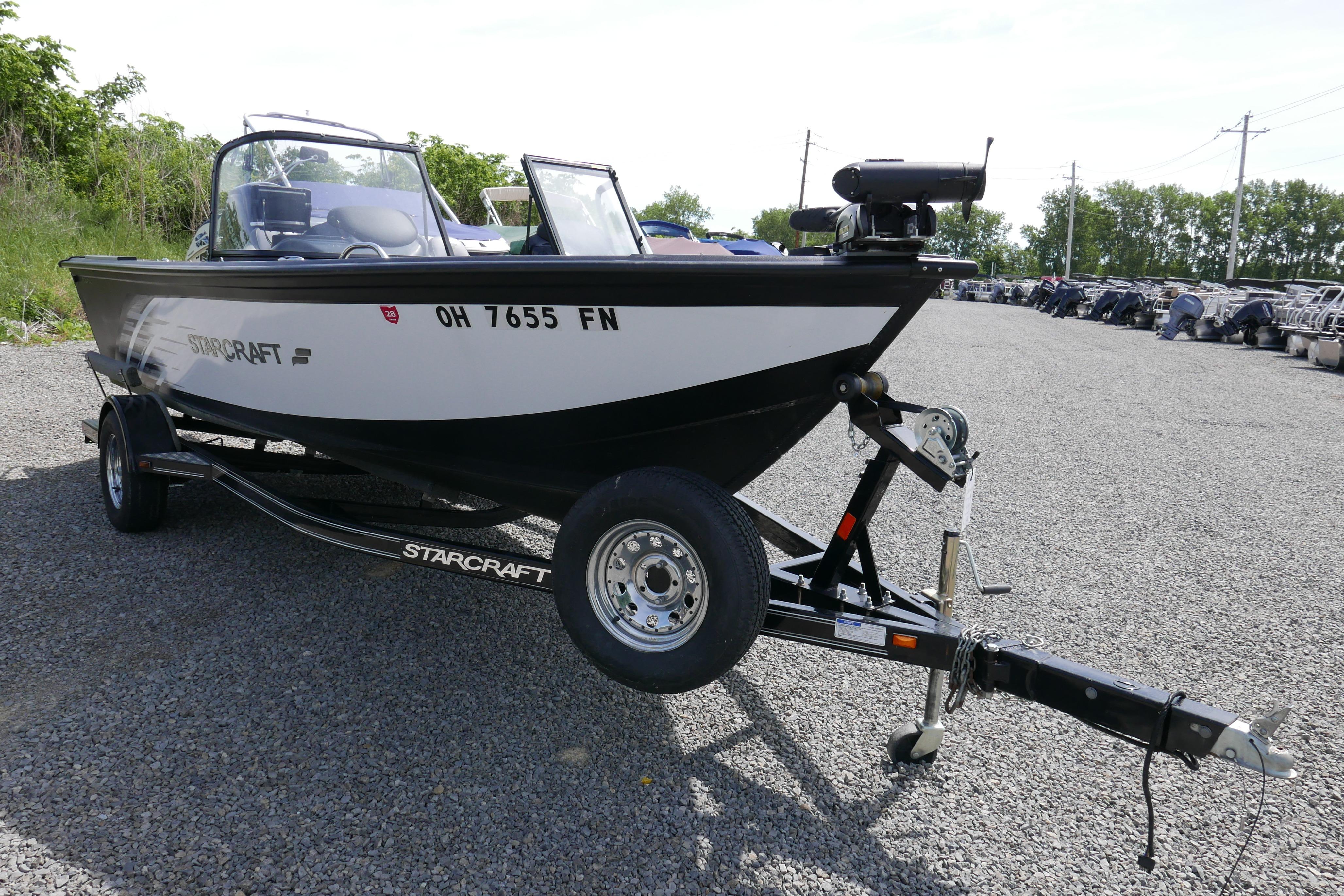 2016 Starcraft Titan 186 boat on trailer, parked on gravel lot with trees in background.